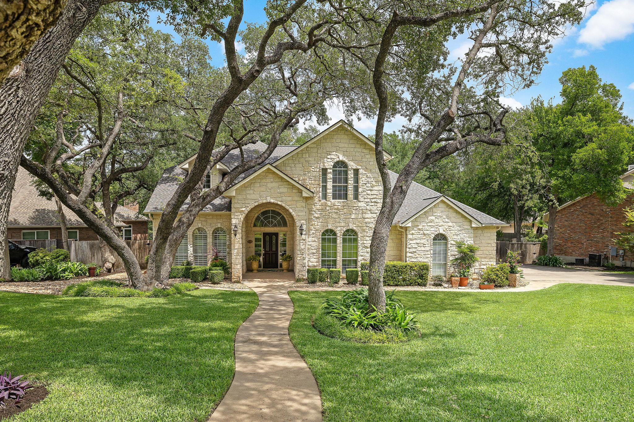 Stone facade residence featuring a covered arched