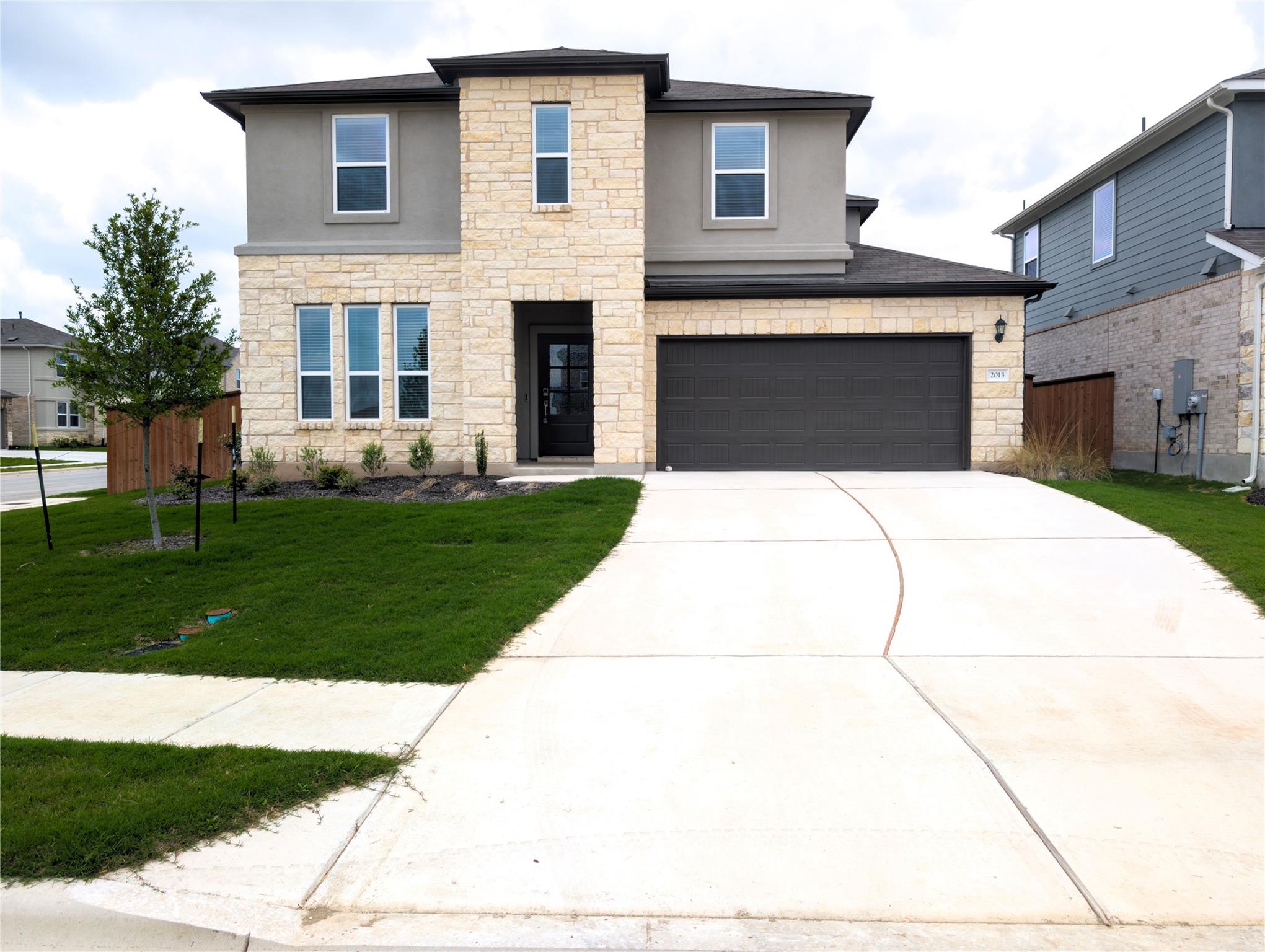 Contemporary two-story residence featuring a ston