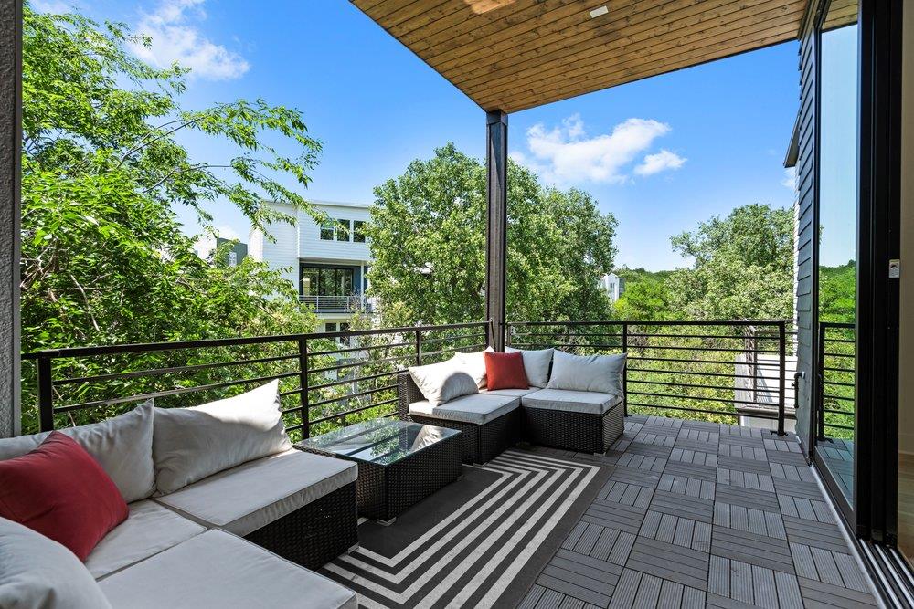 Expansive covered balcony featuring wood-paneled 