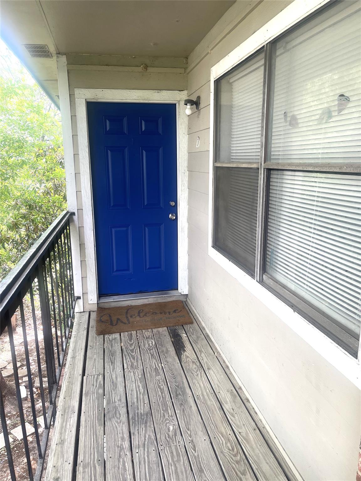 Vibrant blue paneled entry door with exterior wal