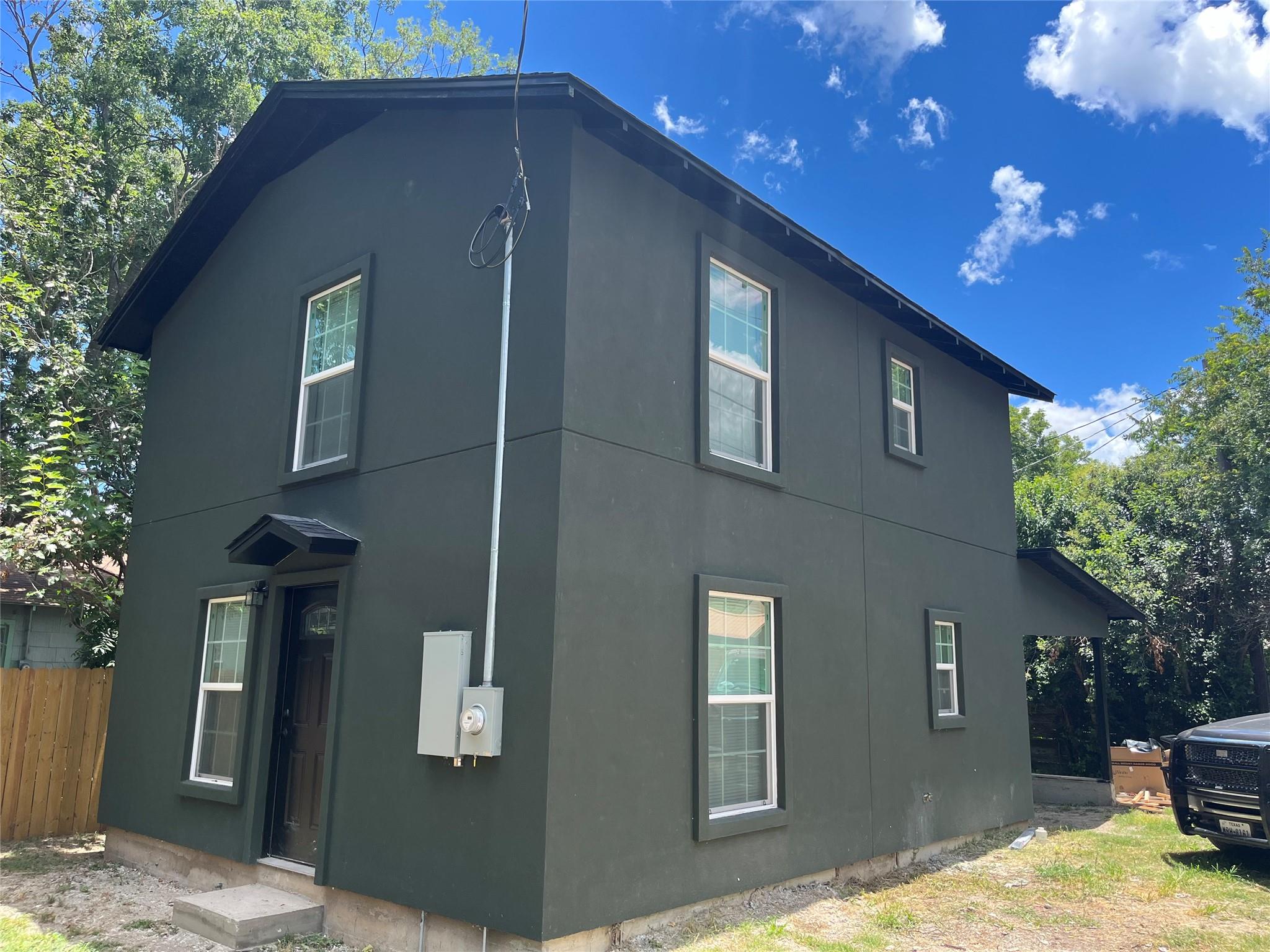 Two-story residential structure featuring a dark 