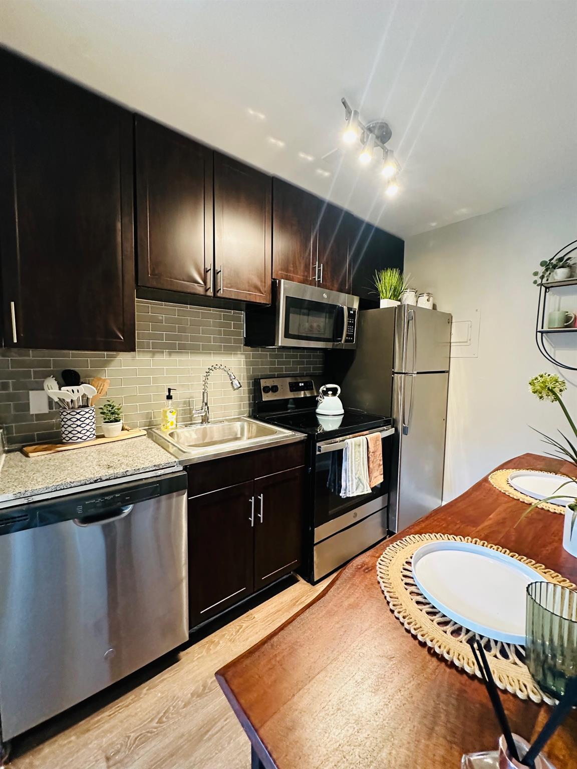 Kitchen featuring dark wood-finish cabinetry, sta