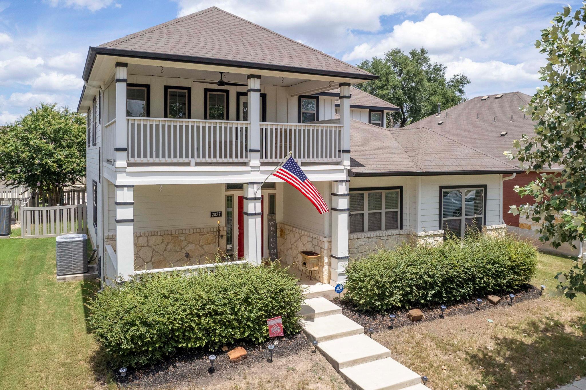 Two-story residence featuring white siding, a pro