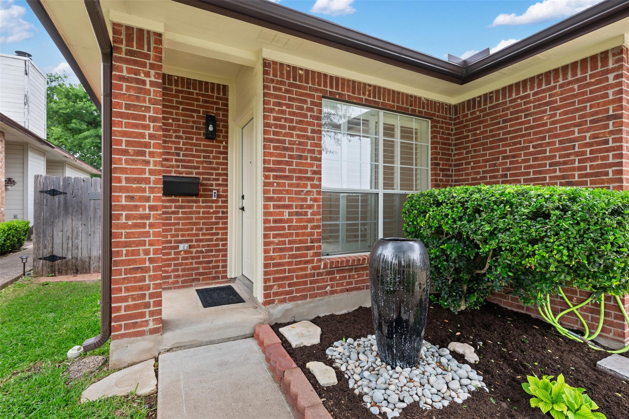Brick exterior with a covered entry, feature wind