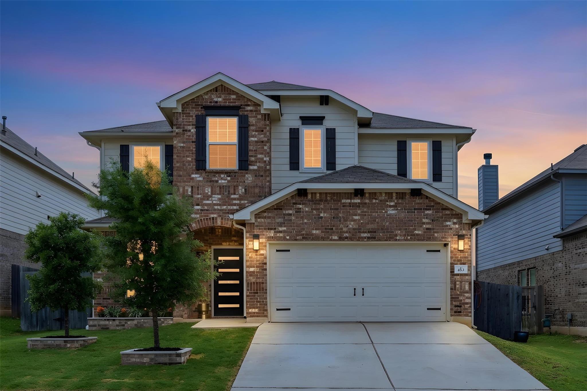 Two-story residence featuring a brick and siding 