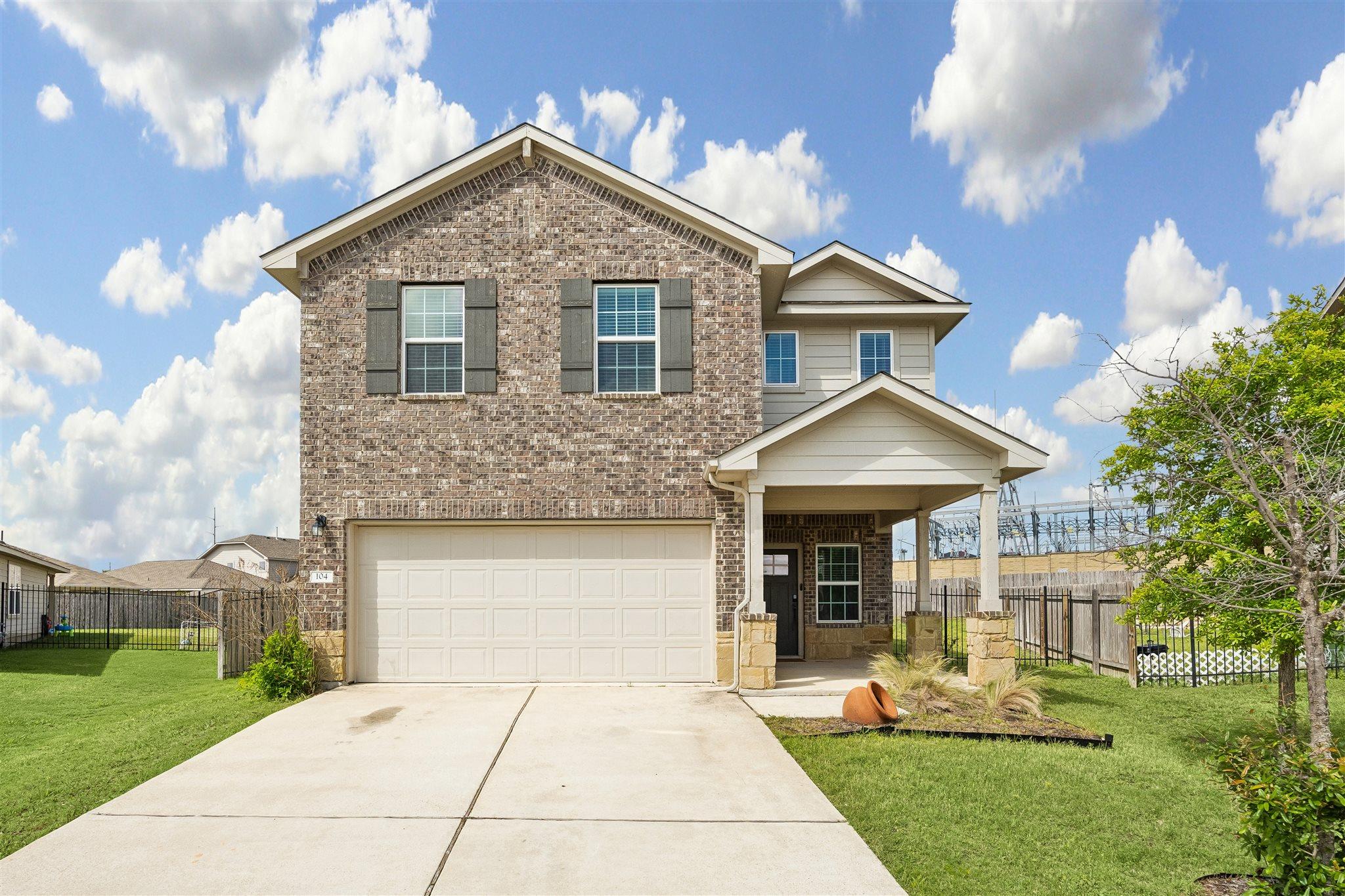 Two-story residence featuring a brick and siding 