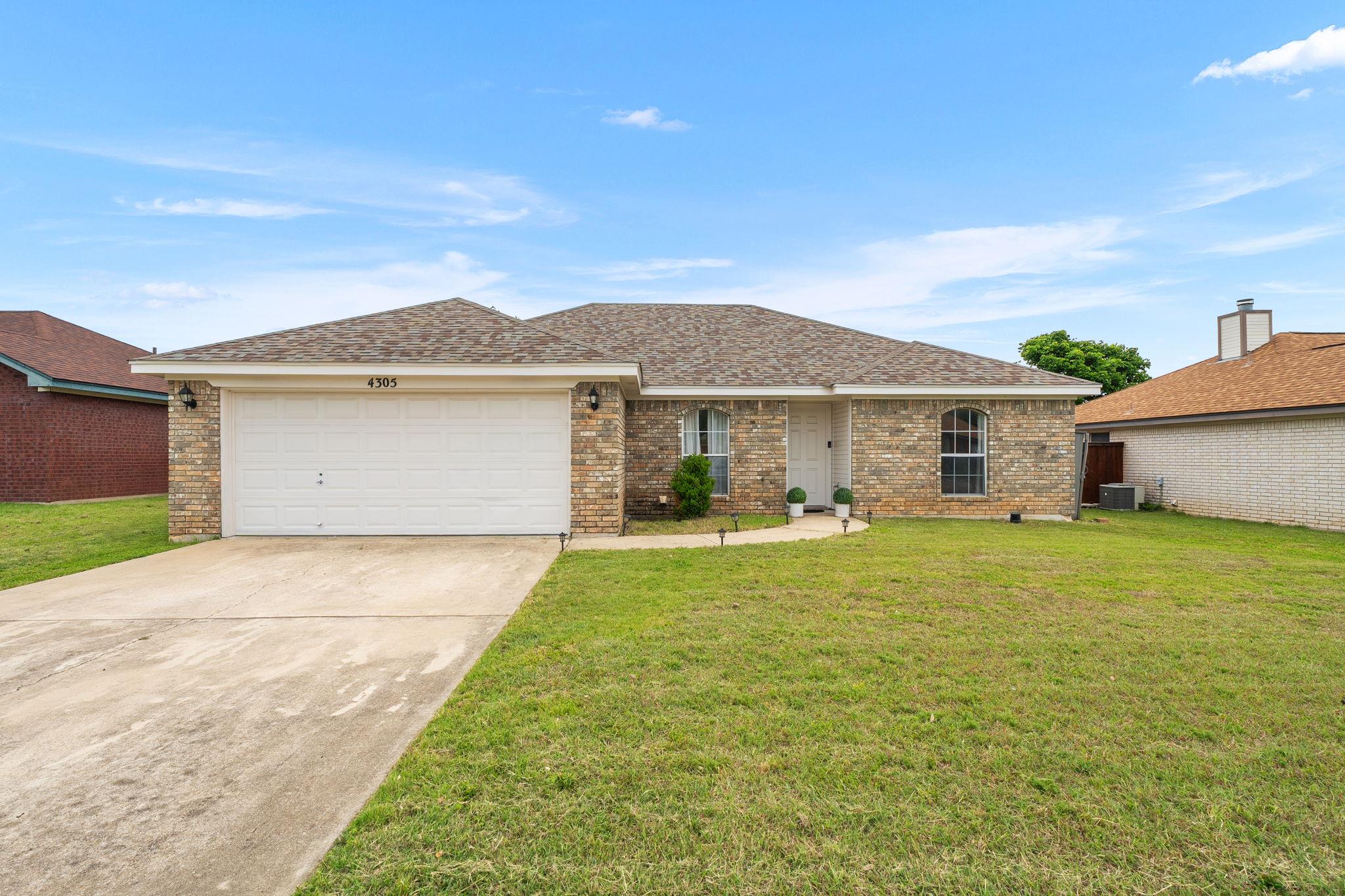 Brick exterior featuring a two-car garage with a 