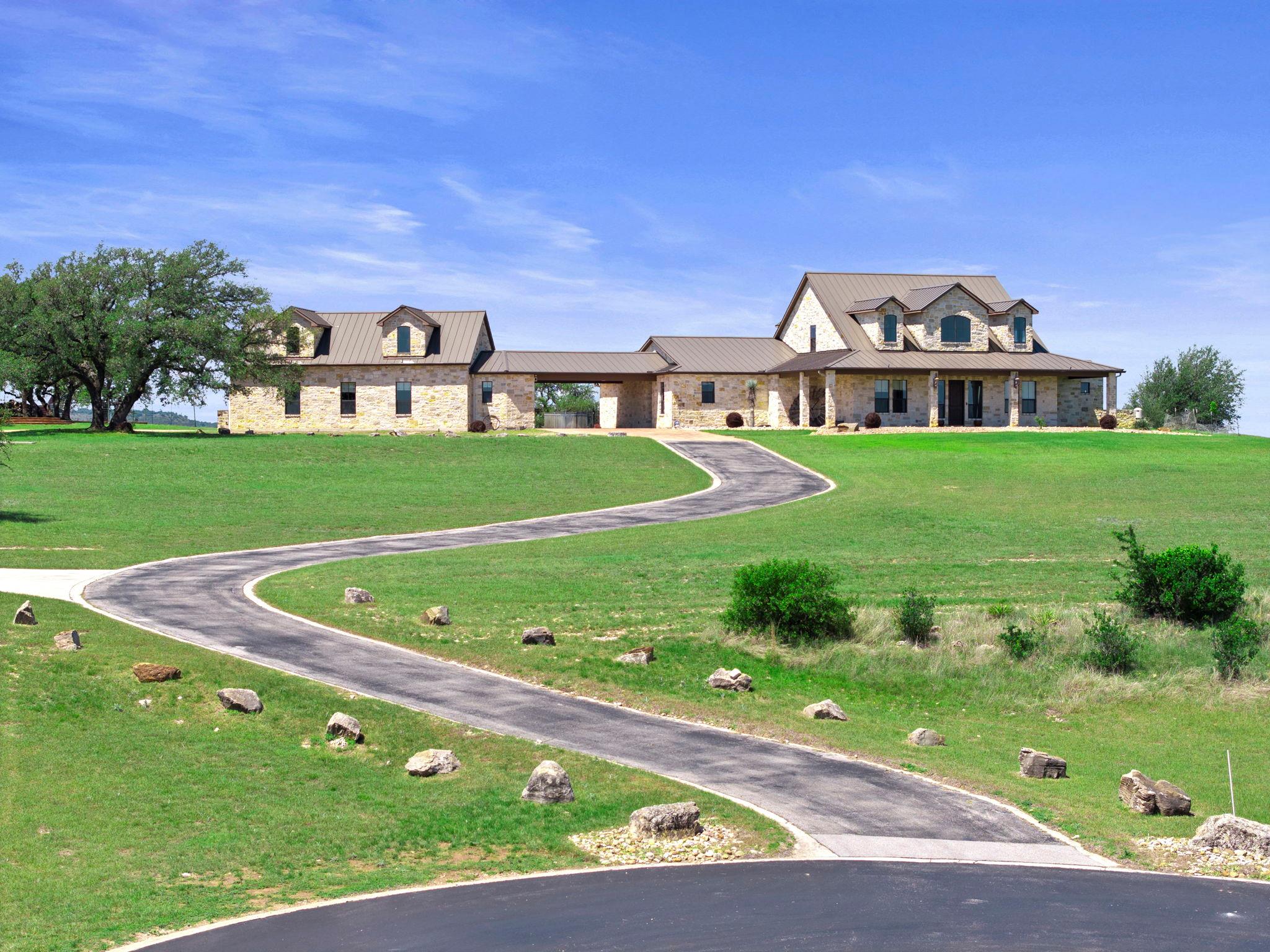 Sprawling stone exterior residence featuring a me