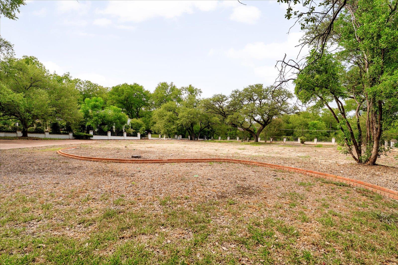 Expansive land parcel featuring mature trees, a w