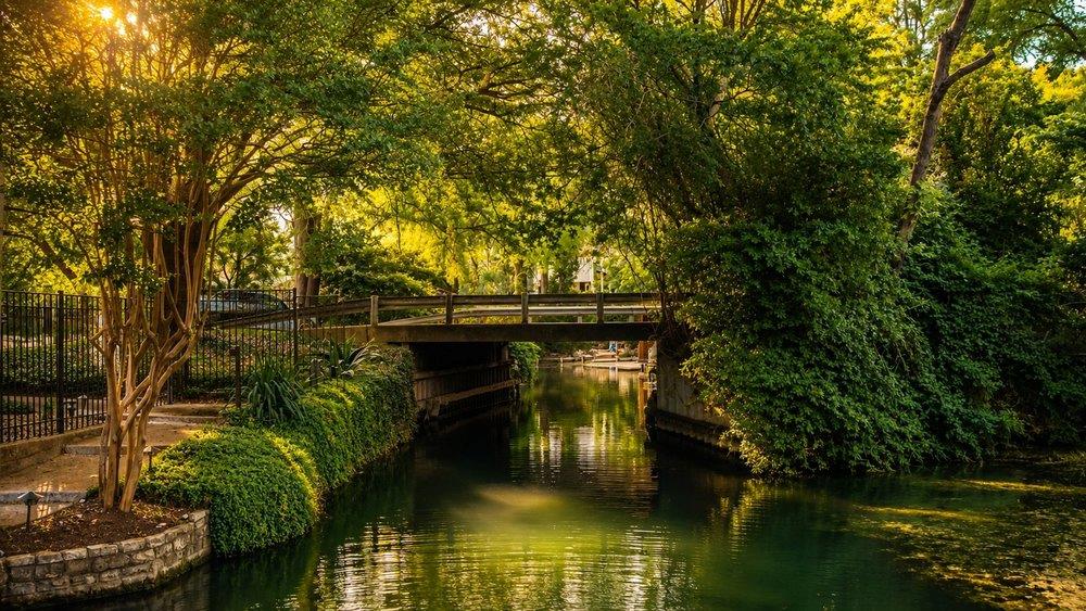 Wood bridge spanning a tranquil waterway, flanked