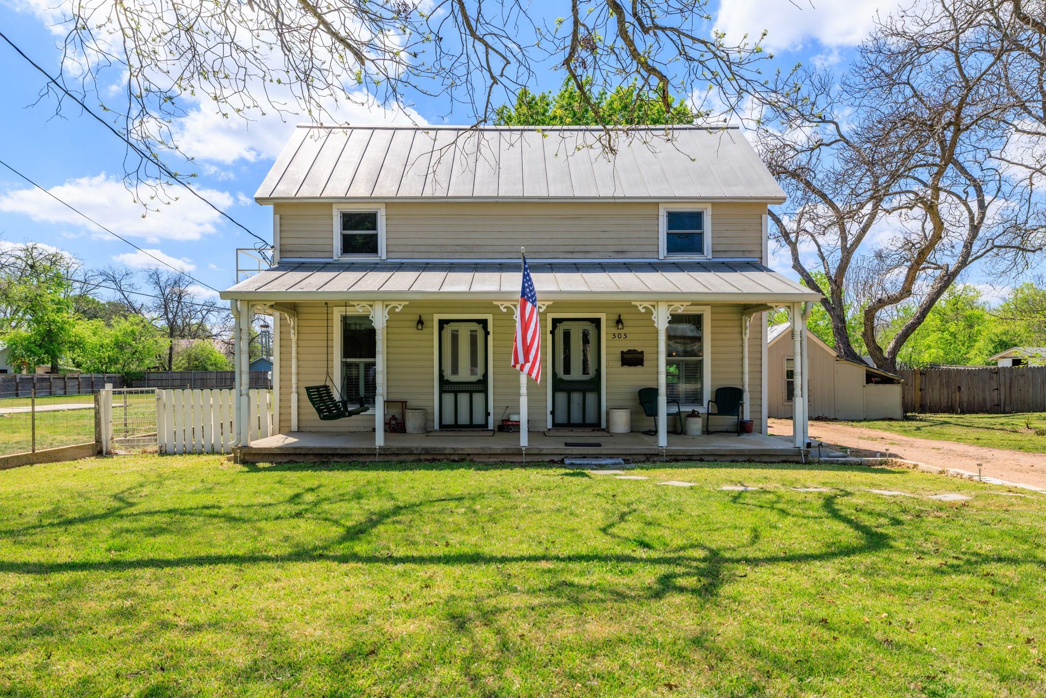 Two-story residence featuring a metal roof, front