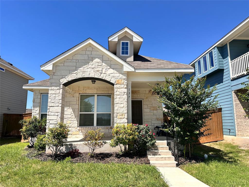 Stone facade home featuring an arched entryway, g
