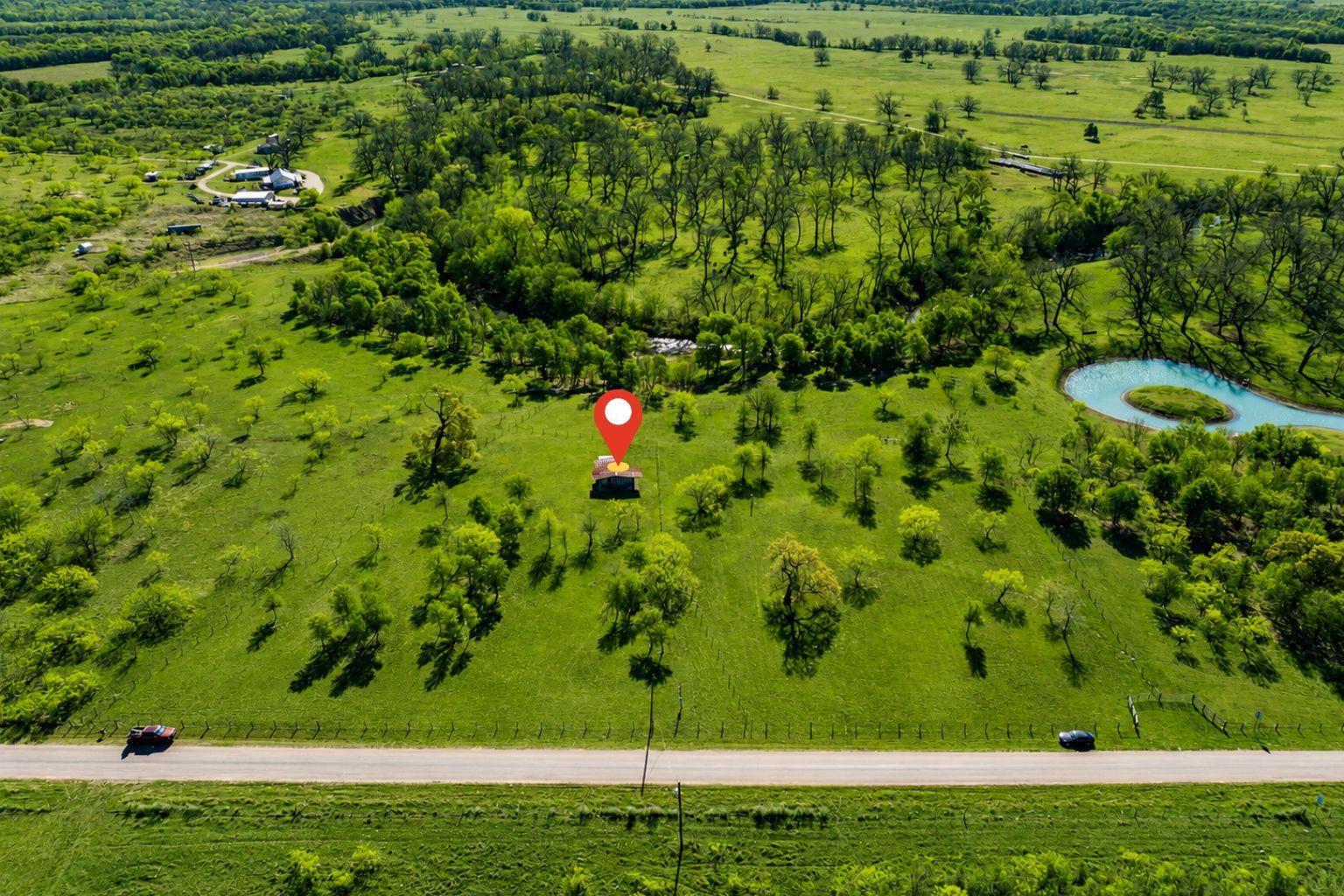 Expansive green landscape with scattered trees, a