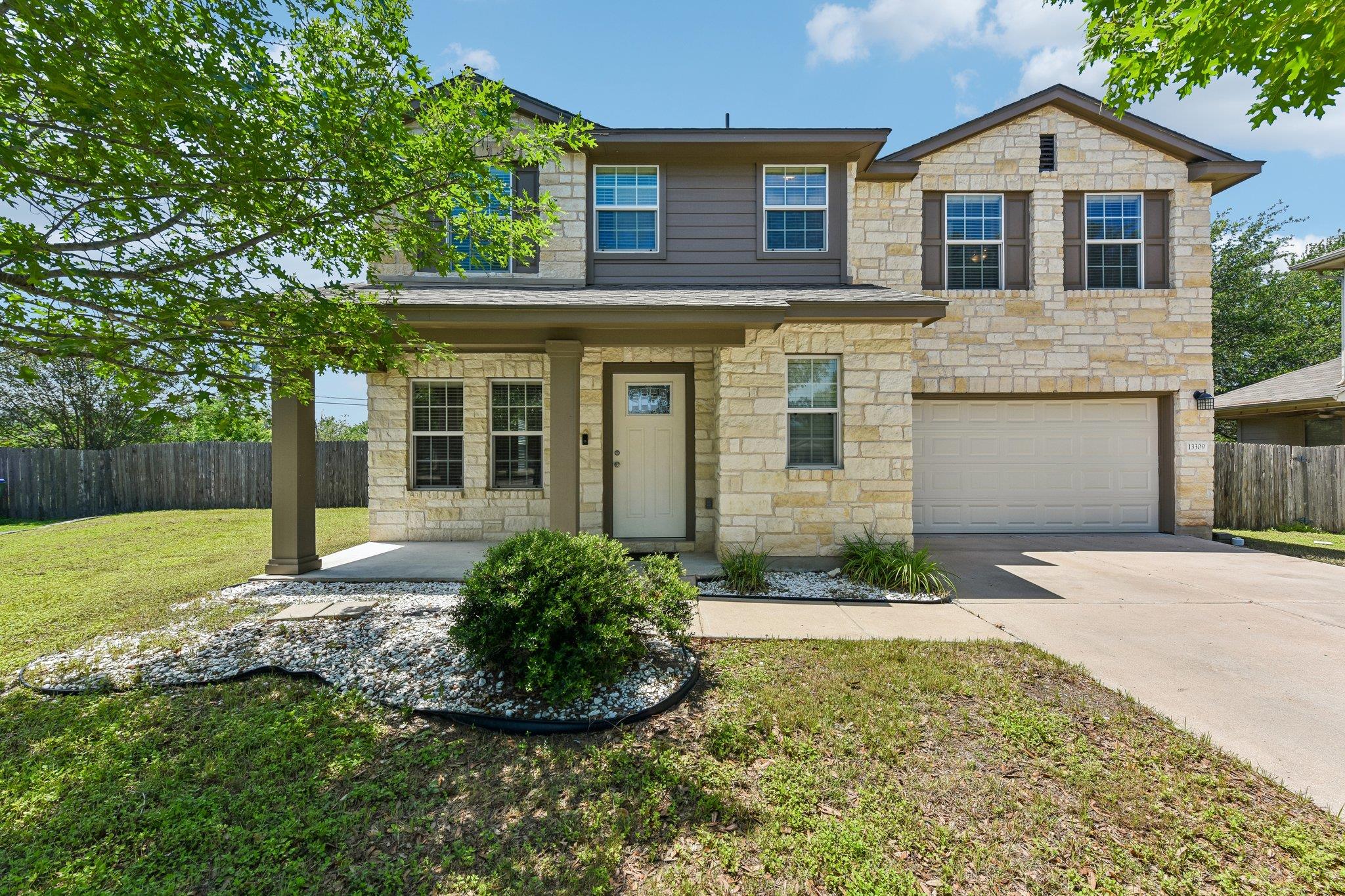 Two-story residence featuring a stone and siding 
