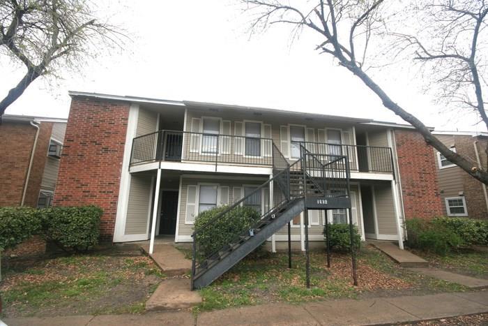 Two-story apartment building featuring brick and 
