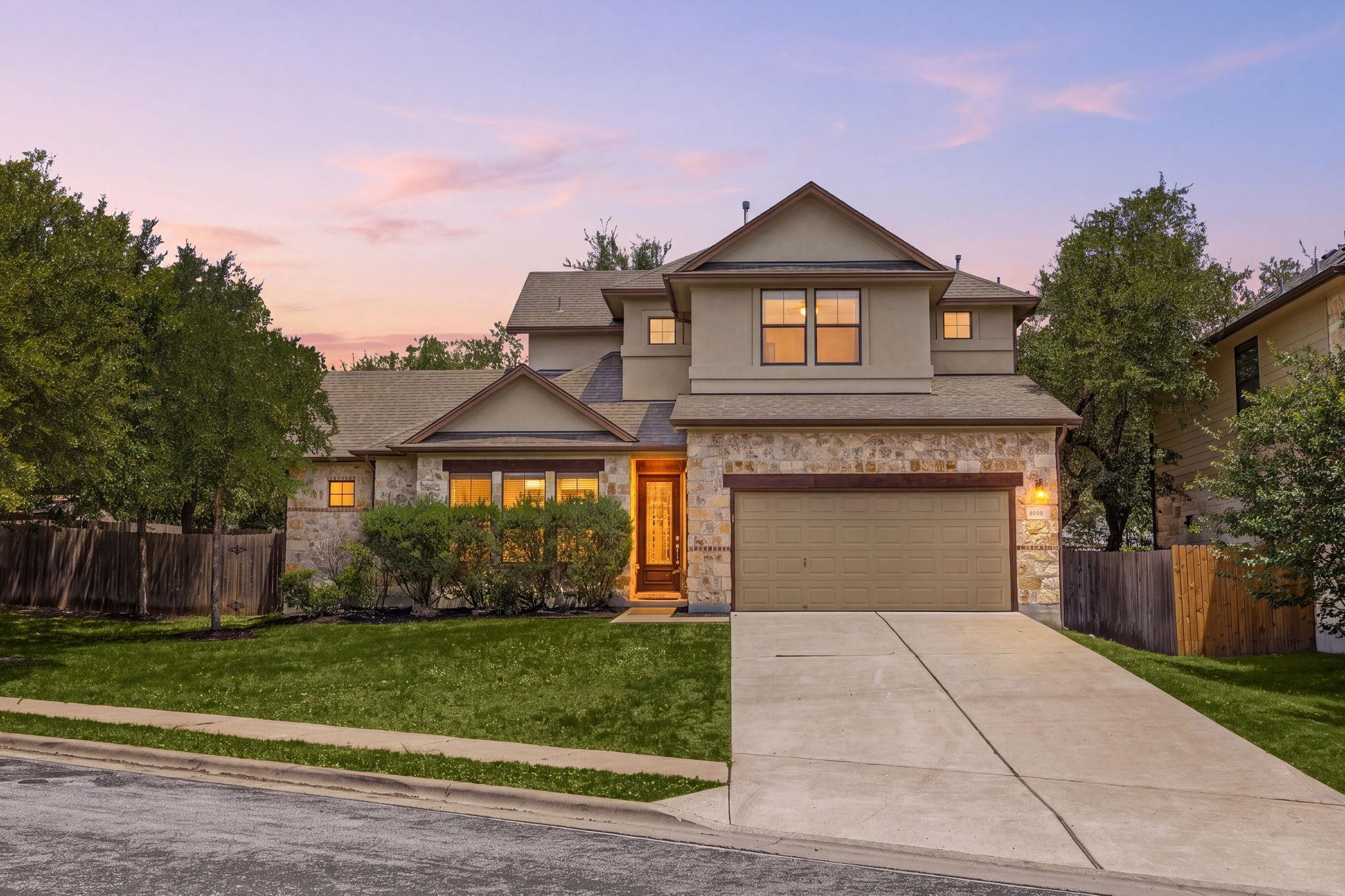 Two-story residence featuring a stone and stucco 