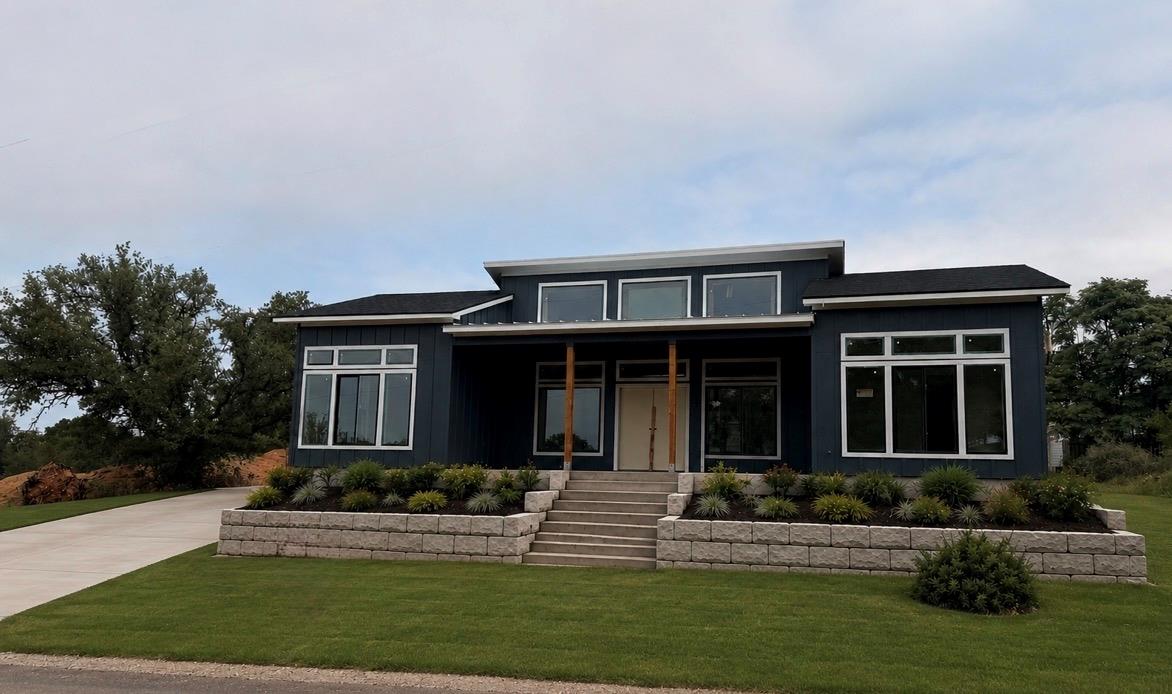 Modern exterior with dark siding, large windows, 