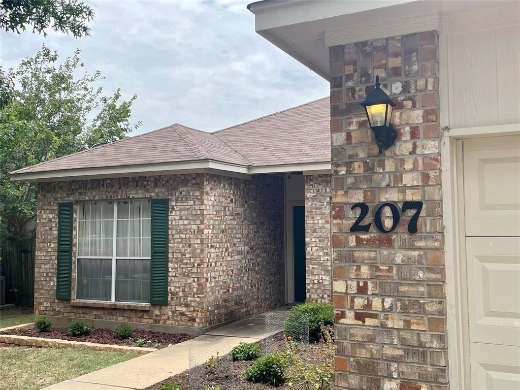 Brick exterior featuring dark green shutters, a c