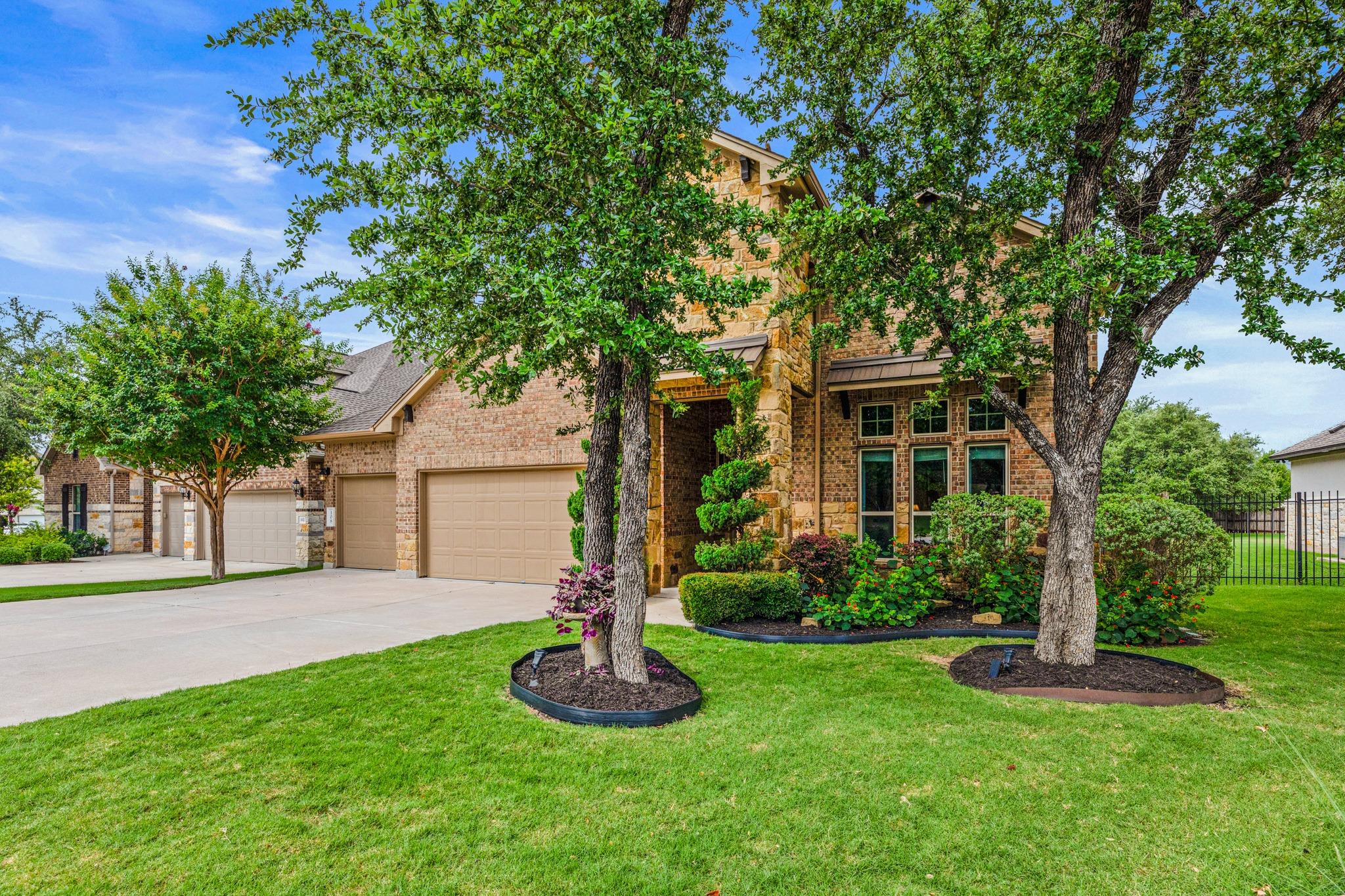 Mature trees and vibrant landscaping frame this i