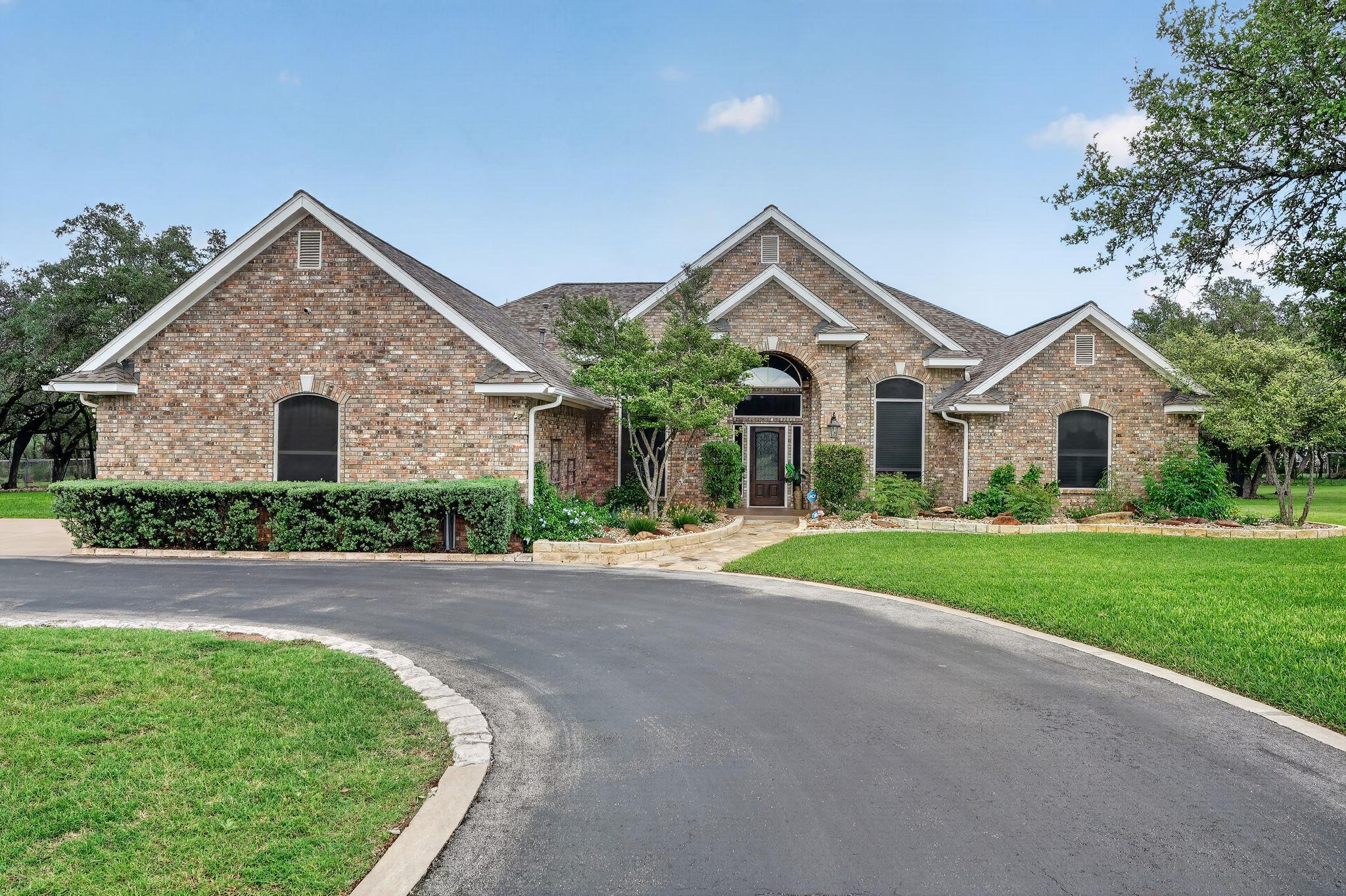 Brick exterior featuring multiple gables, an arch