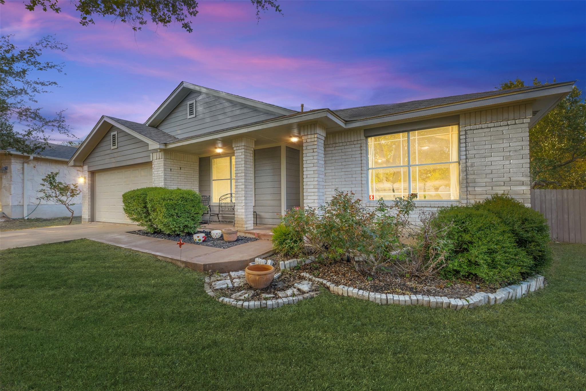 Manicured landscaping complements the classic bri