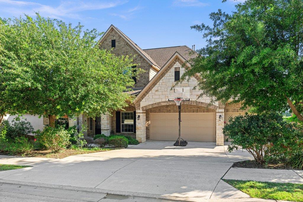 Stone and brick facade home featuring a two-car g
