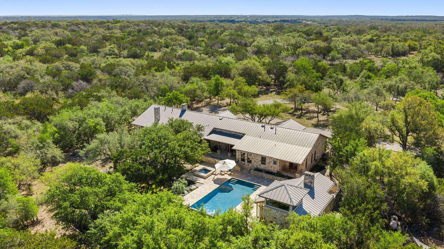 Stone exterior residence with a metal roof surrou