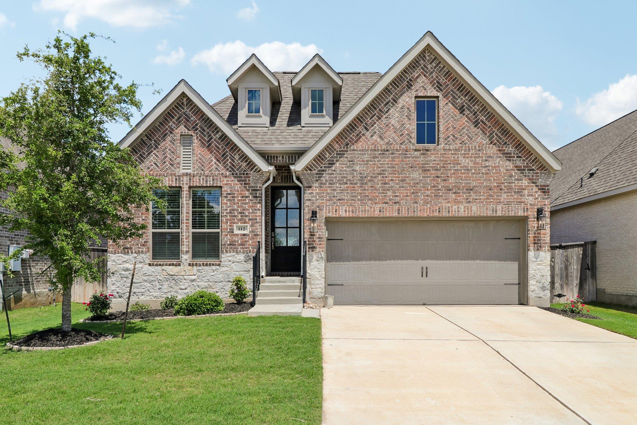 Brick and stone exterior featuring a dark paneled