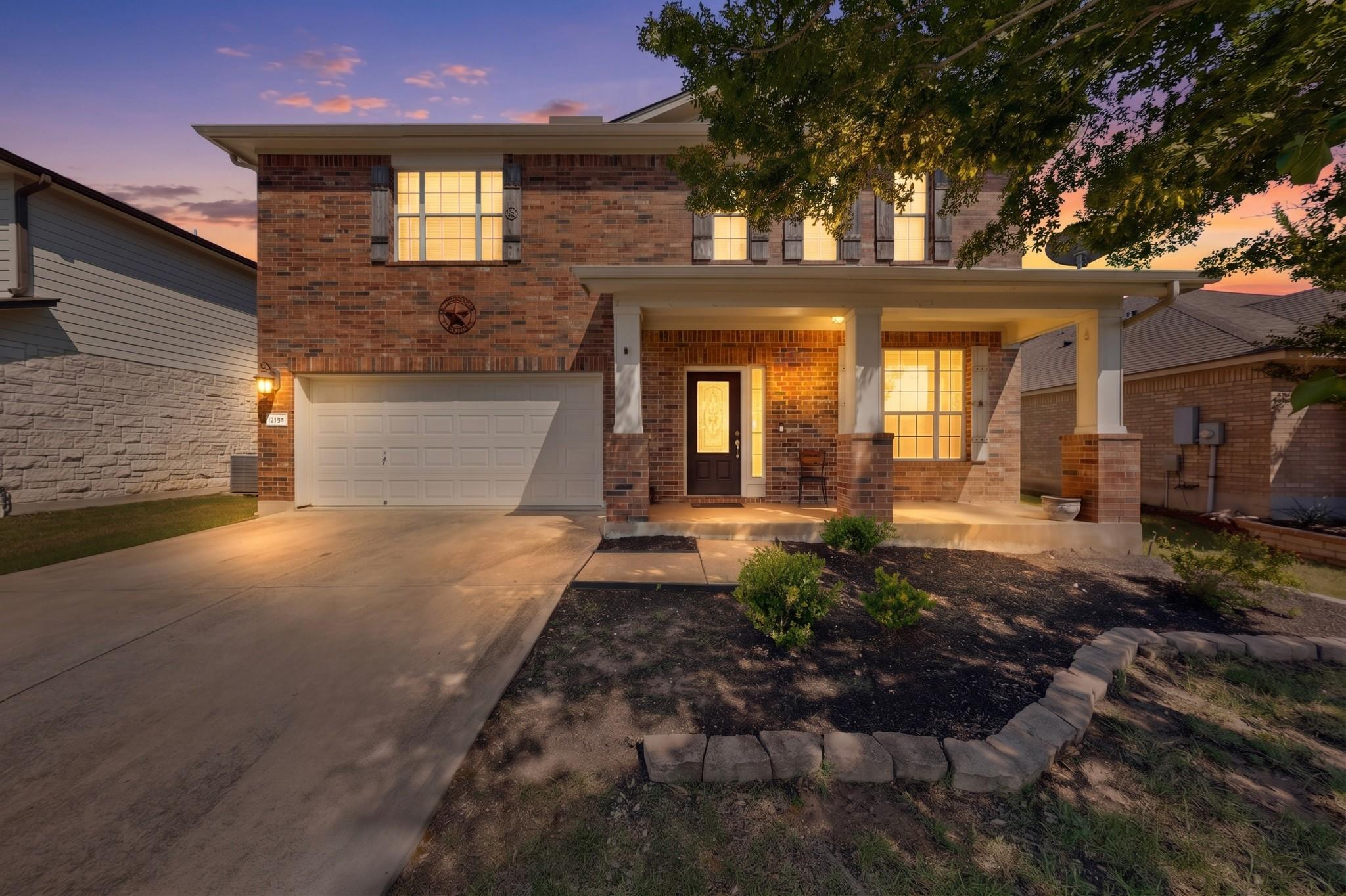 Brick facade residence featuring a covered front 