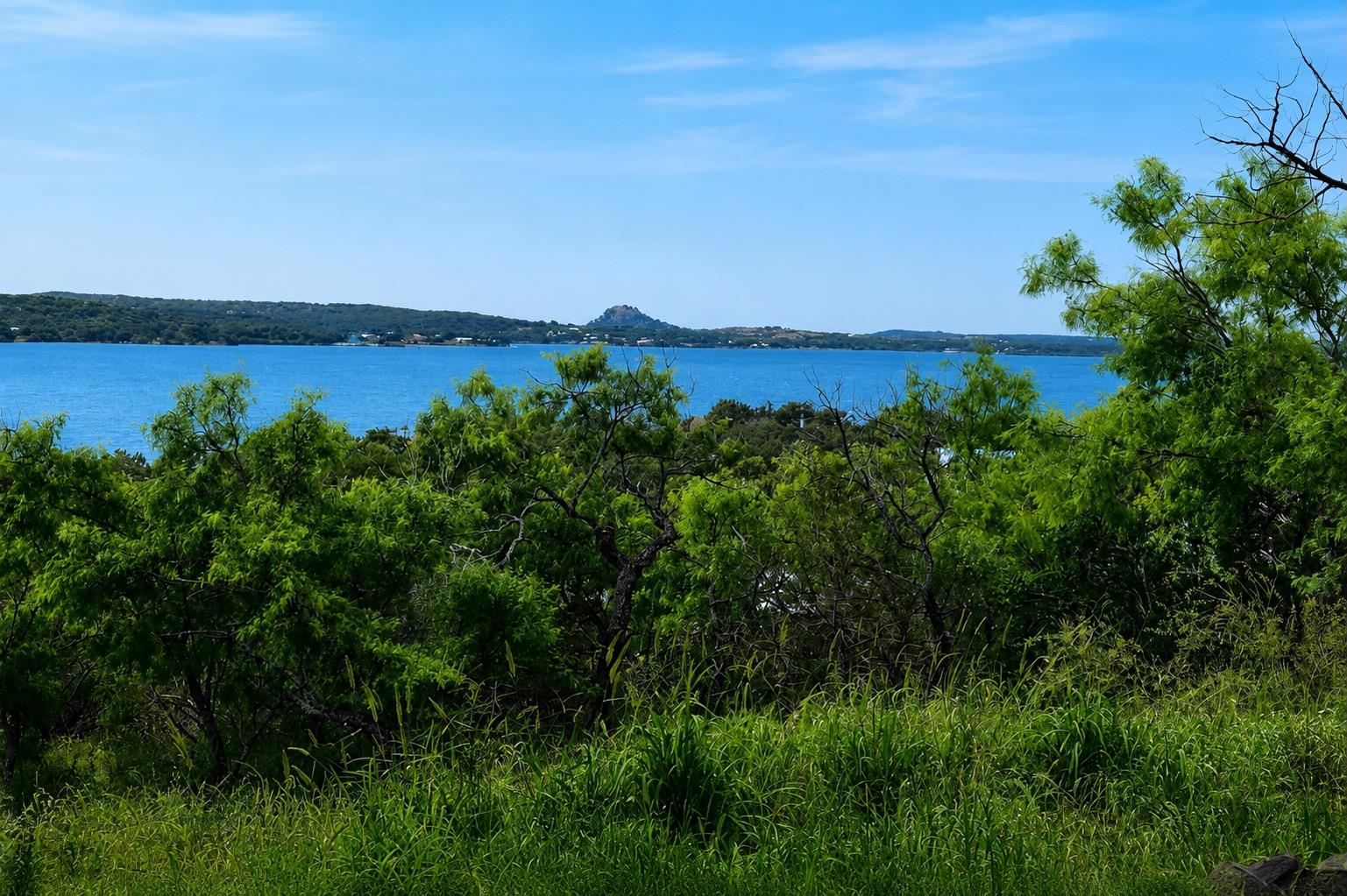 A captivating lake view emerges over verdant tree