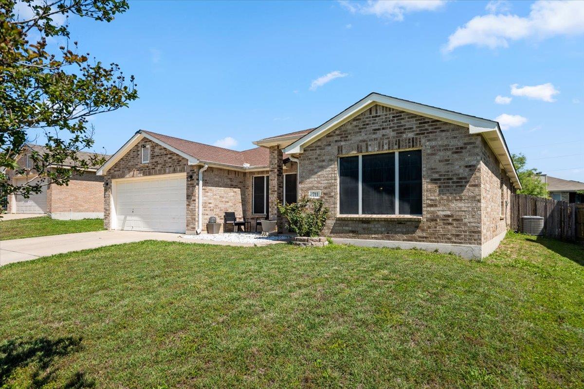 Brick exterior with an attached garage and a conc