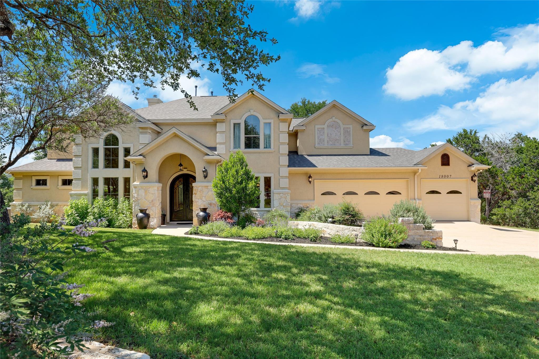 Stucco exterior featuring stone accents, arched e