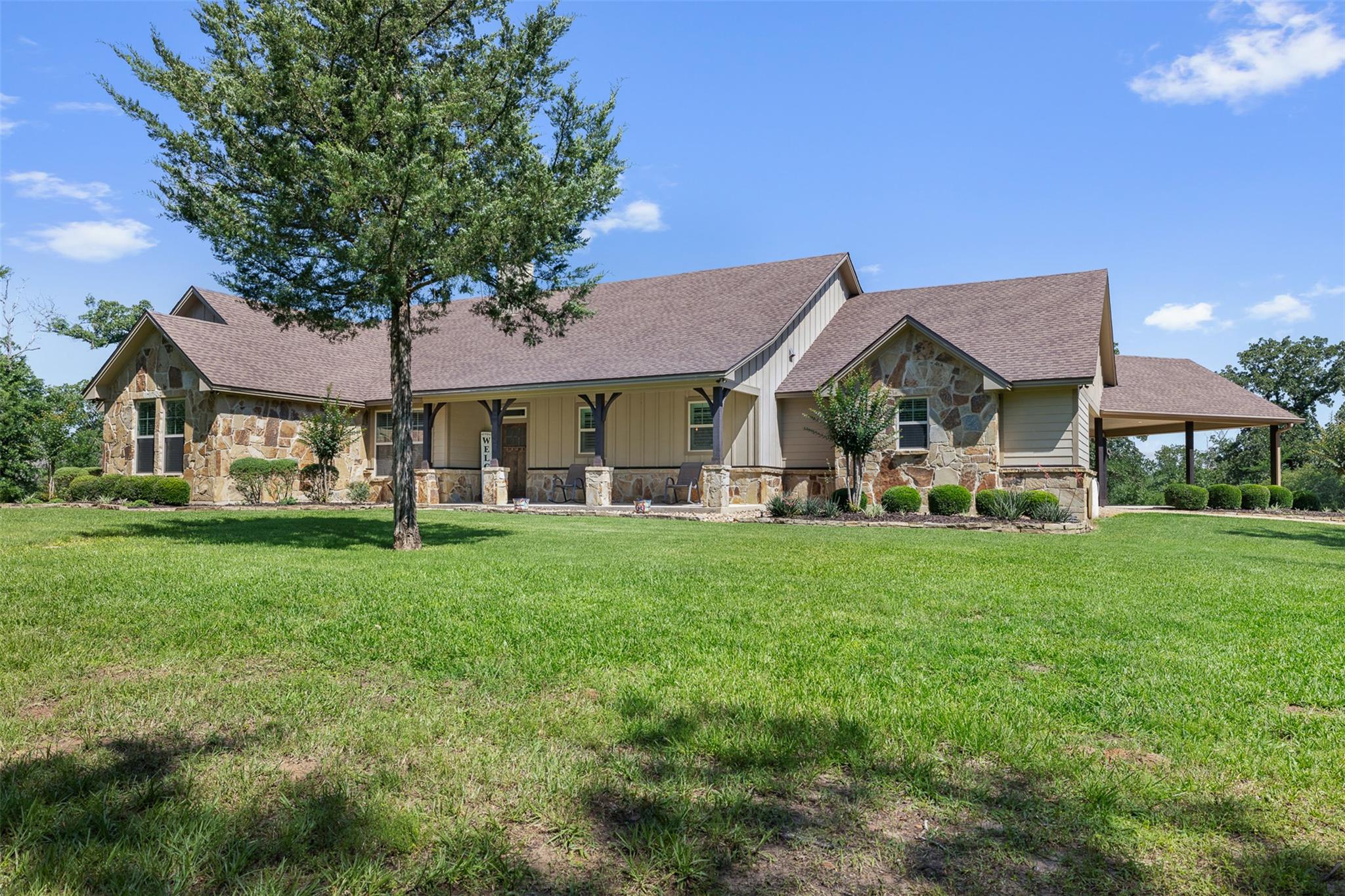 Stone and siding exterior with a covered front en