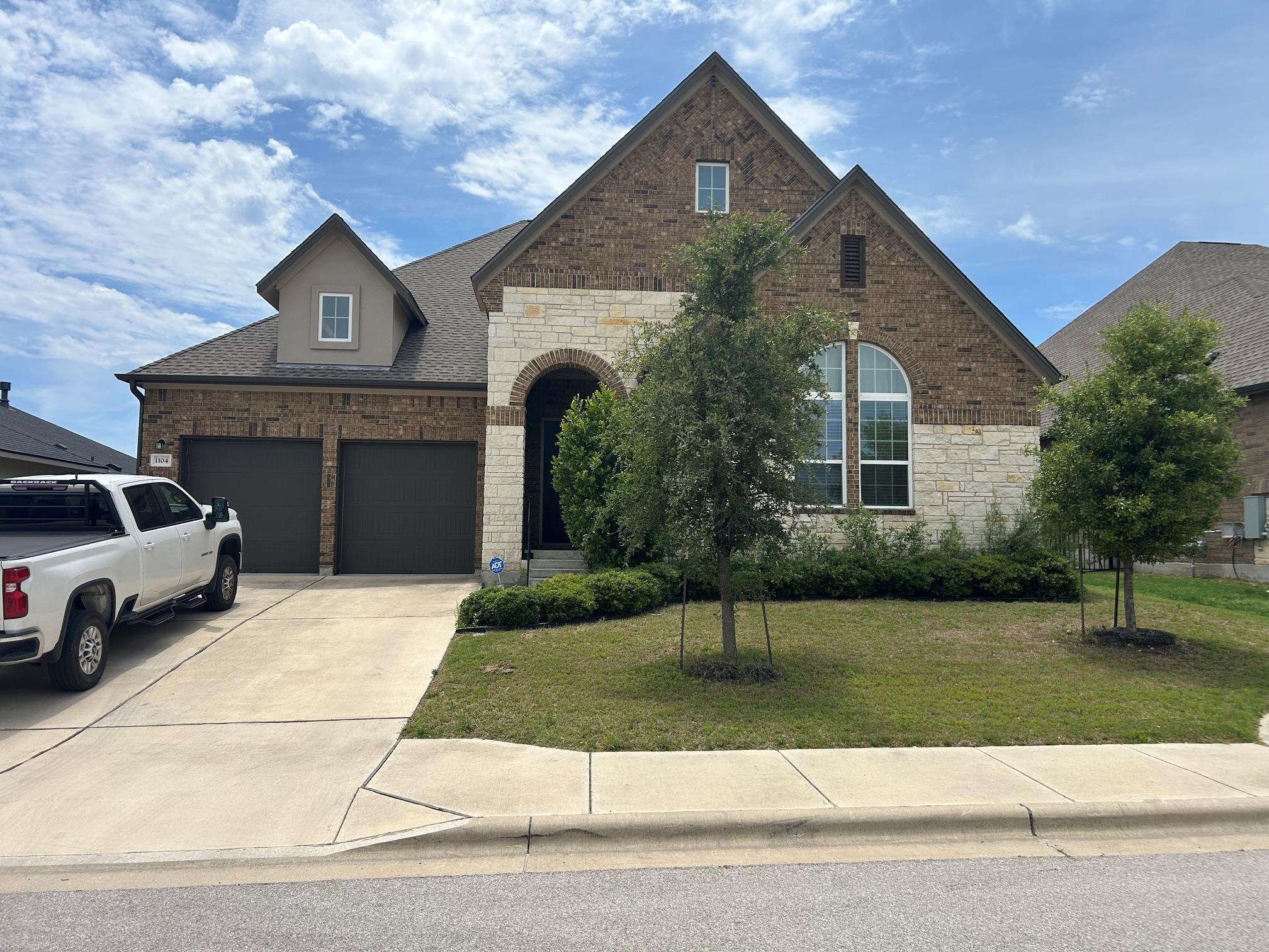 Stone and brick facade home featuring a two-car g