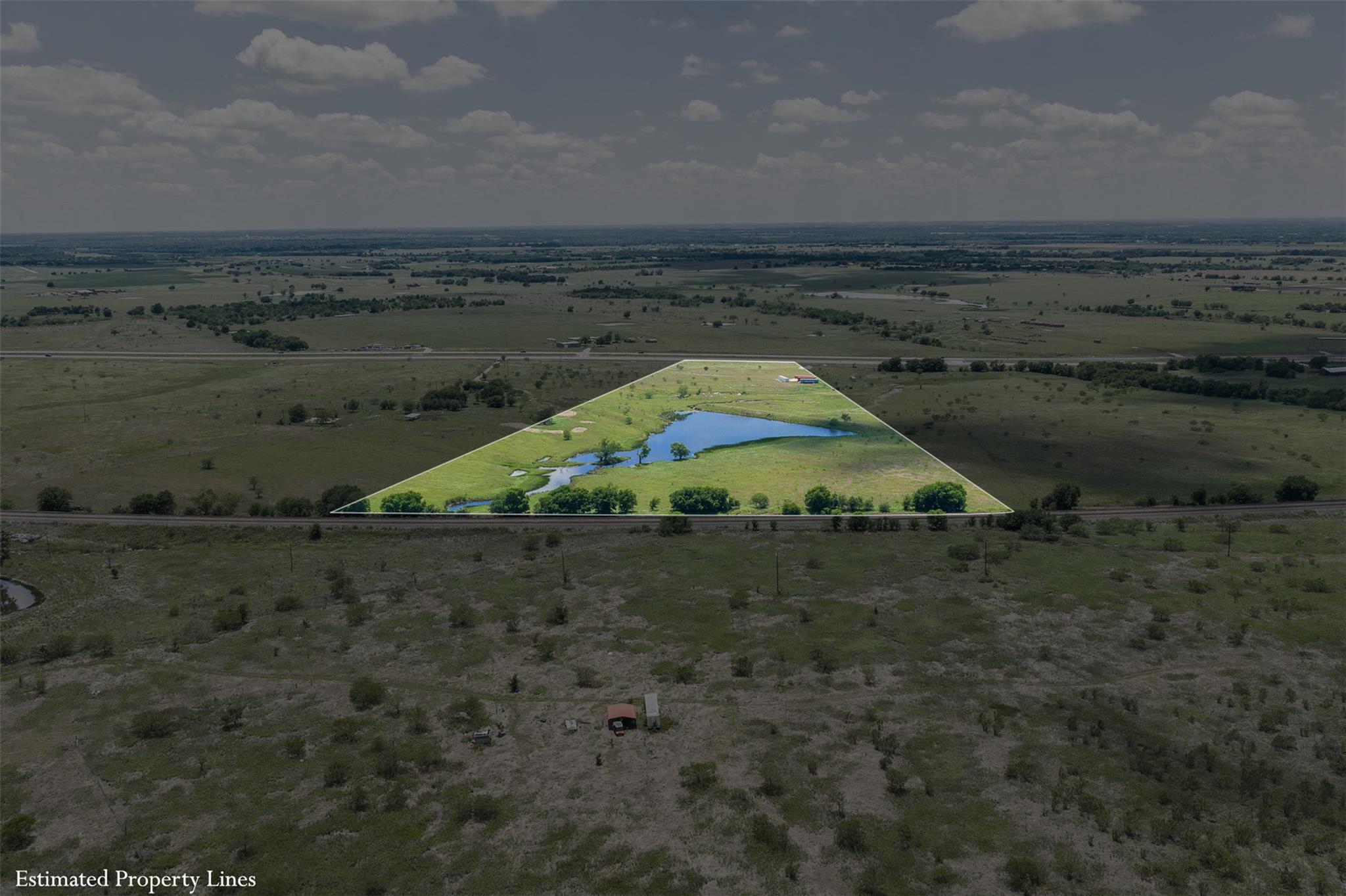 Expansive land parcel featuring a central pond, v