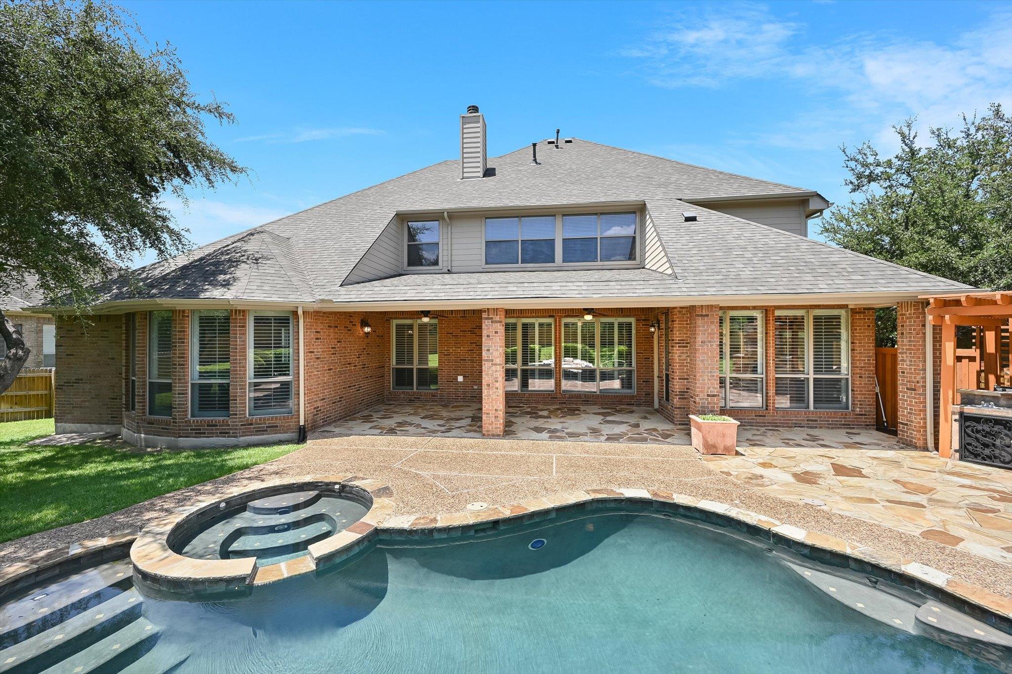 A private backyard oasis features a shimmering po