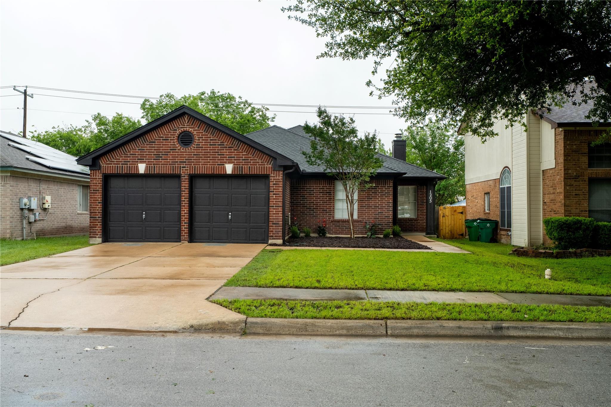 Brick exterior with a prominent two-car garage, f