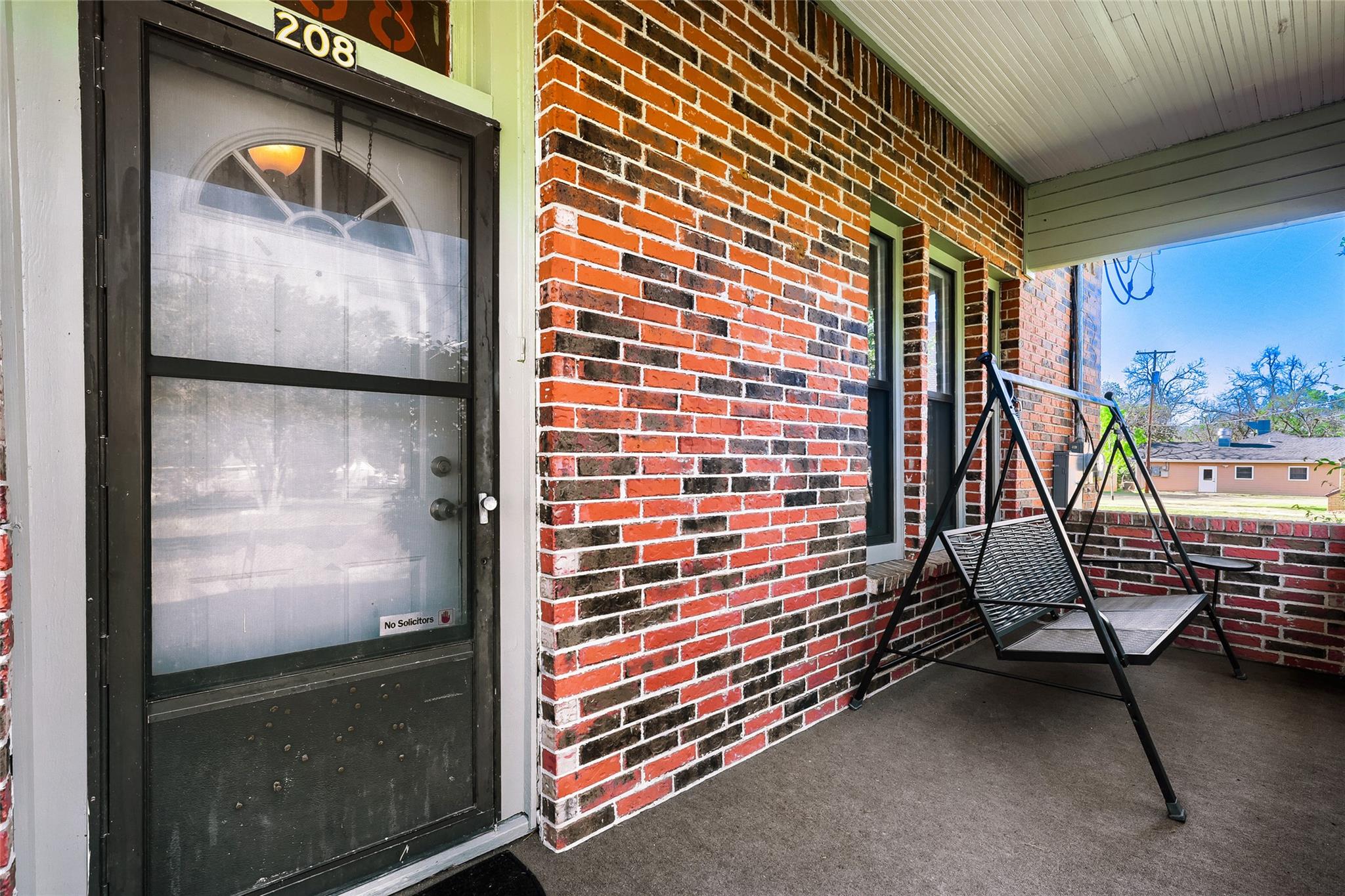 Brick exterior featuring a covered porch