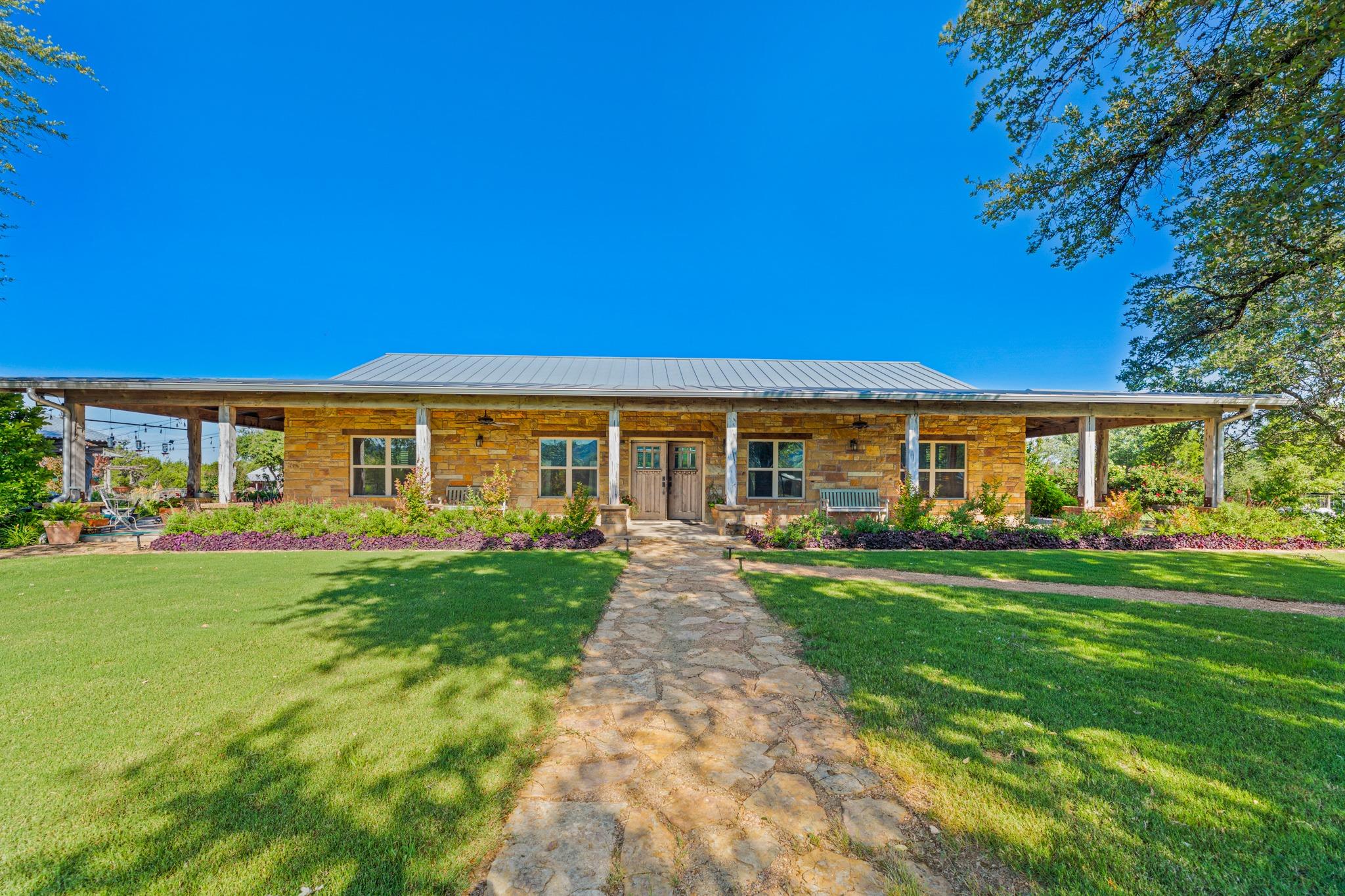 Stone exterior residence featuring a metal roof a