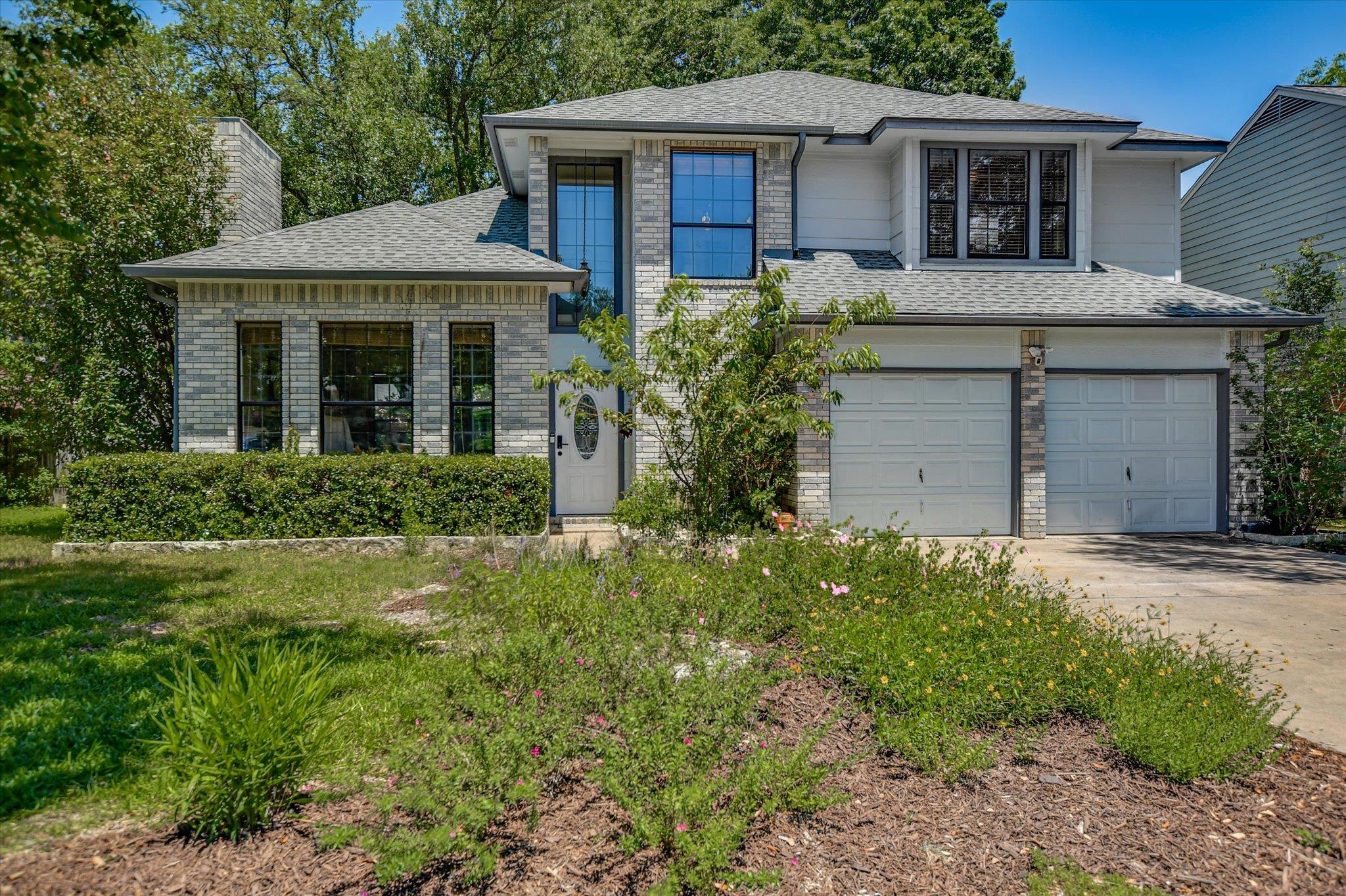 Two-story residence featuring a brick and siding 