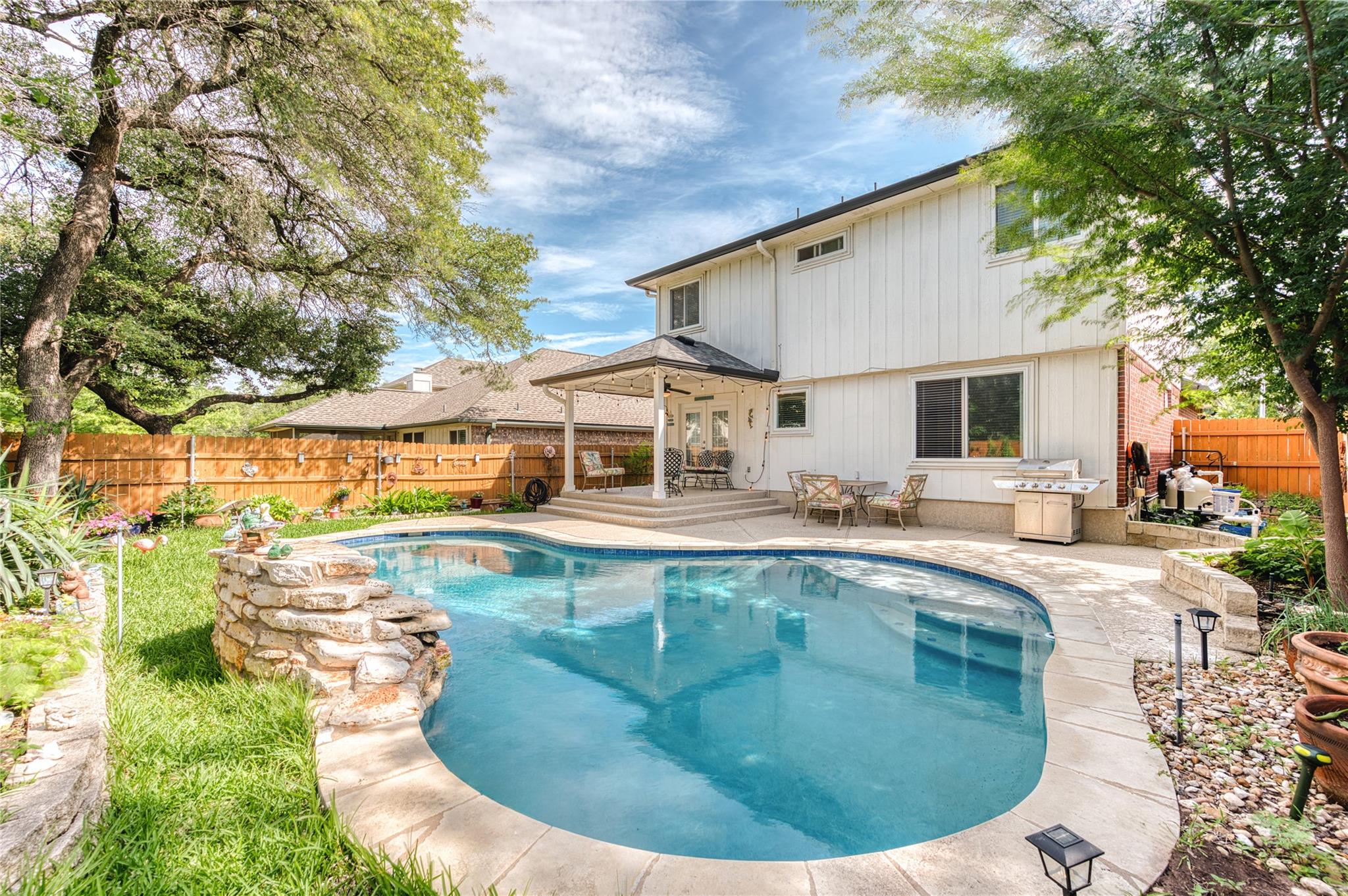 Backyard oasis featuring a curvilinear swimming p