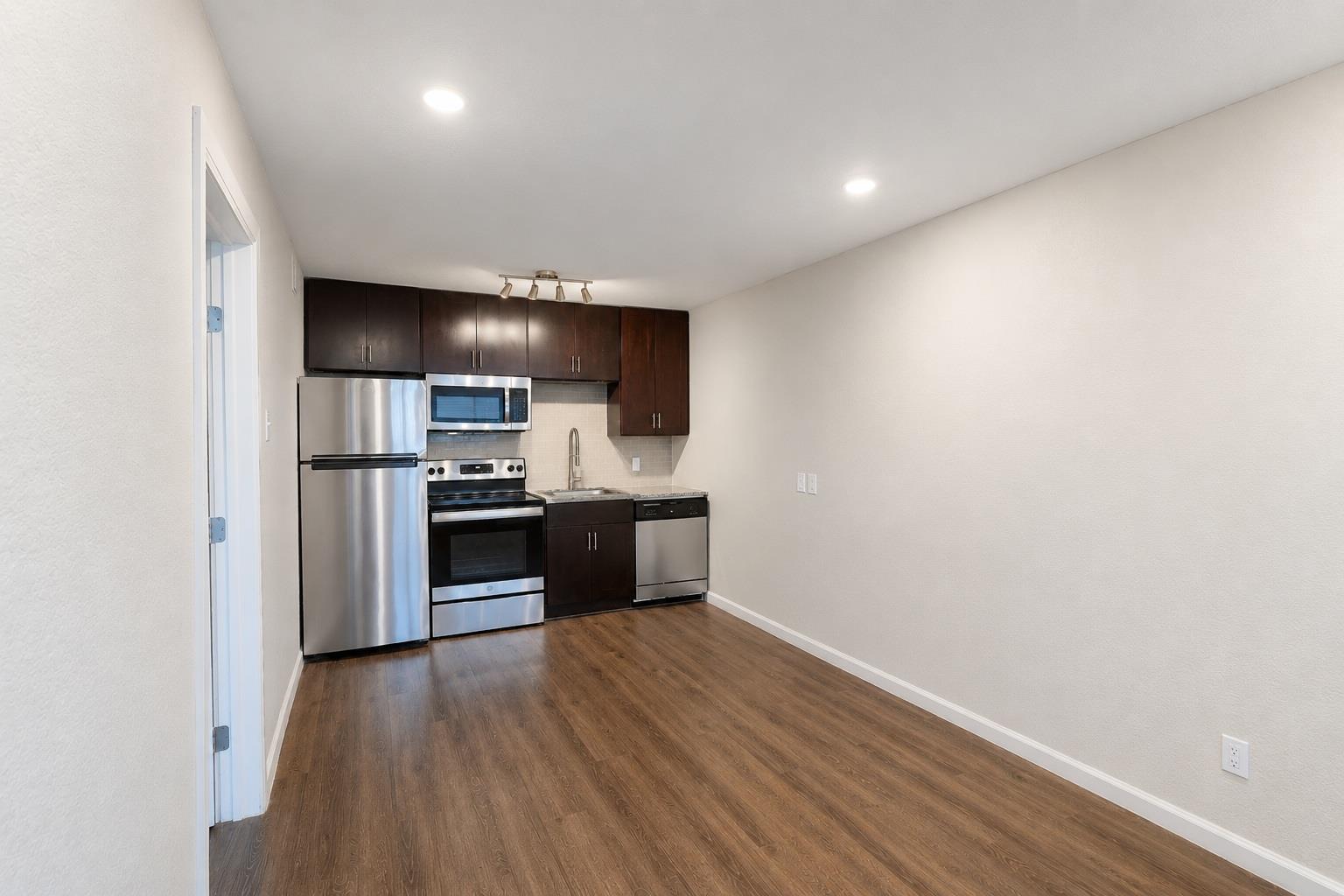 Compact kitchen area with wood-finish flooring, d