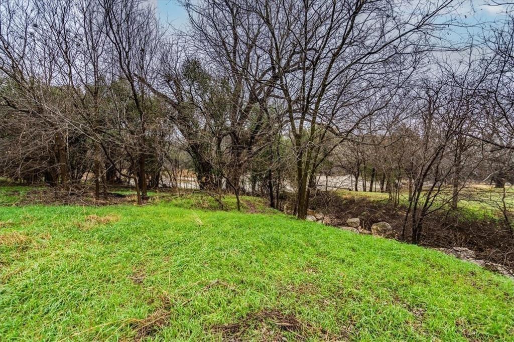 Expansive green lawn with a natural tree line and