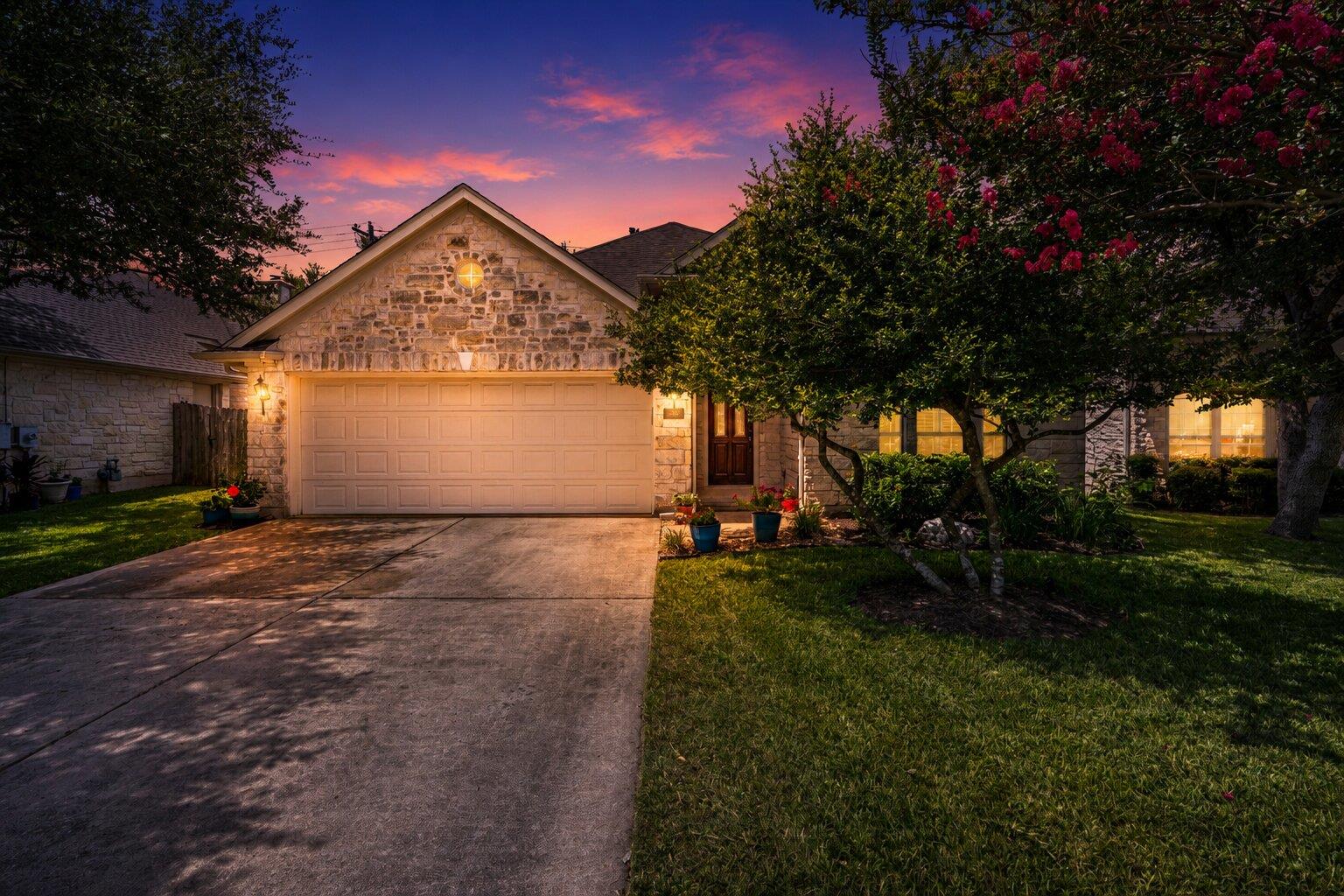 Stone veneer facade and lush landscaping welcome 