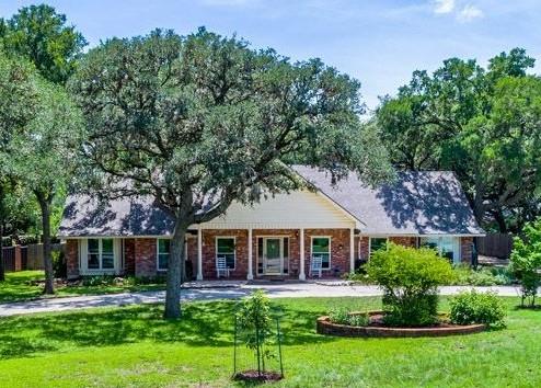 Brick facade residence with a gabled roof and cov