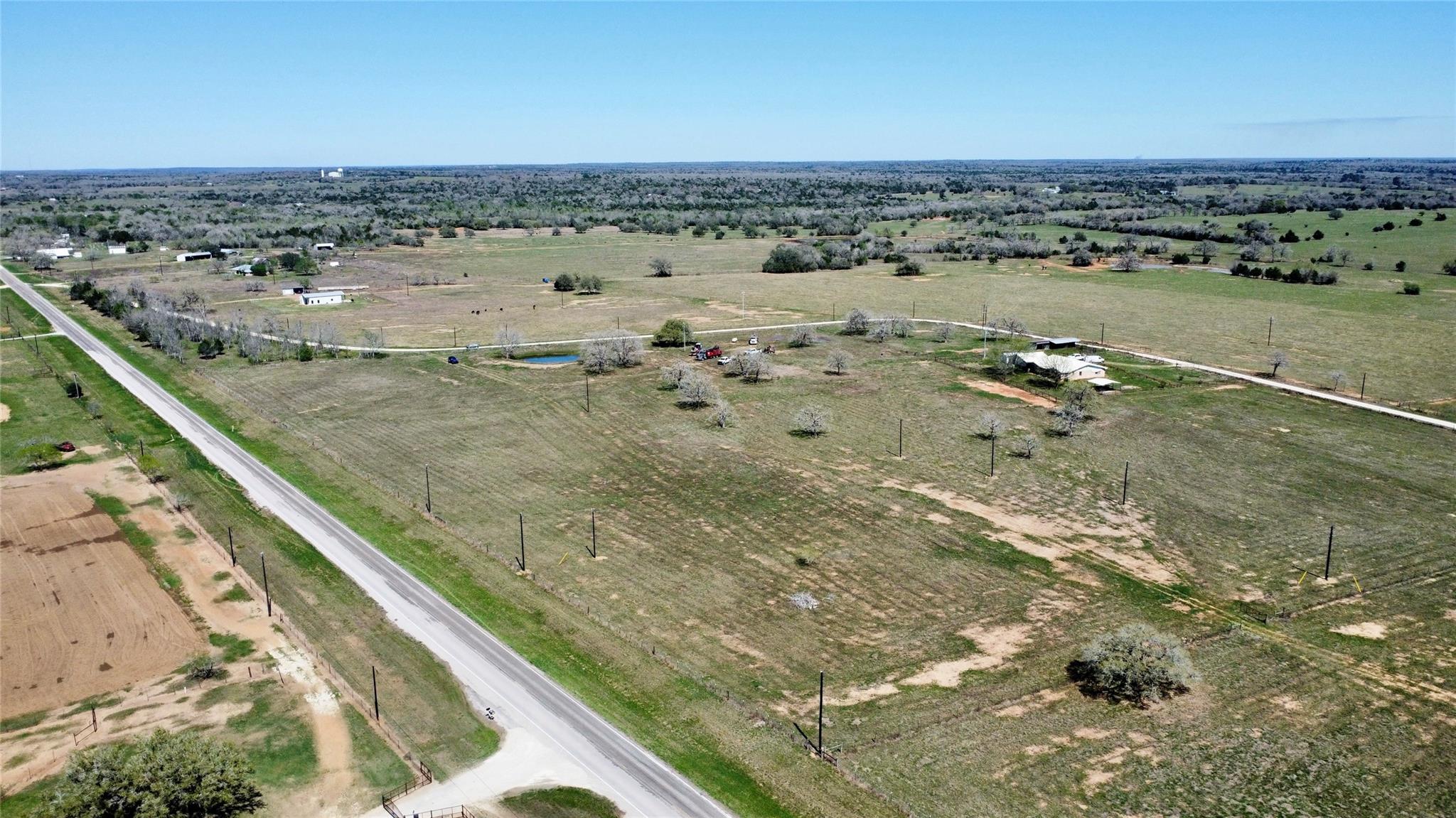 Expansive rural property featuring a paved road f