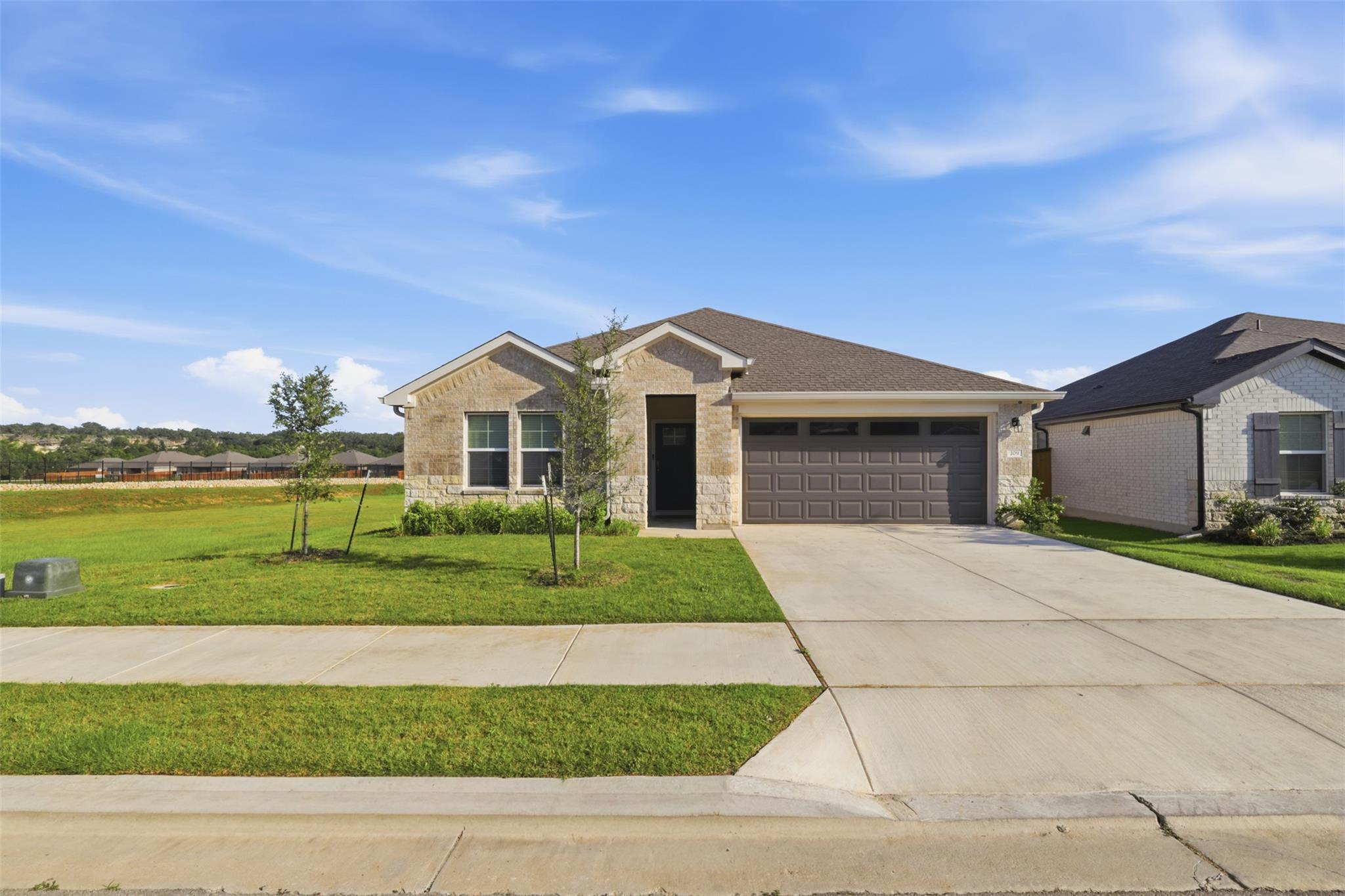 Single-story residence featuring a brick and ston