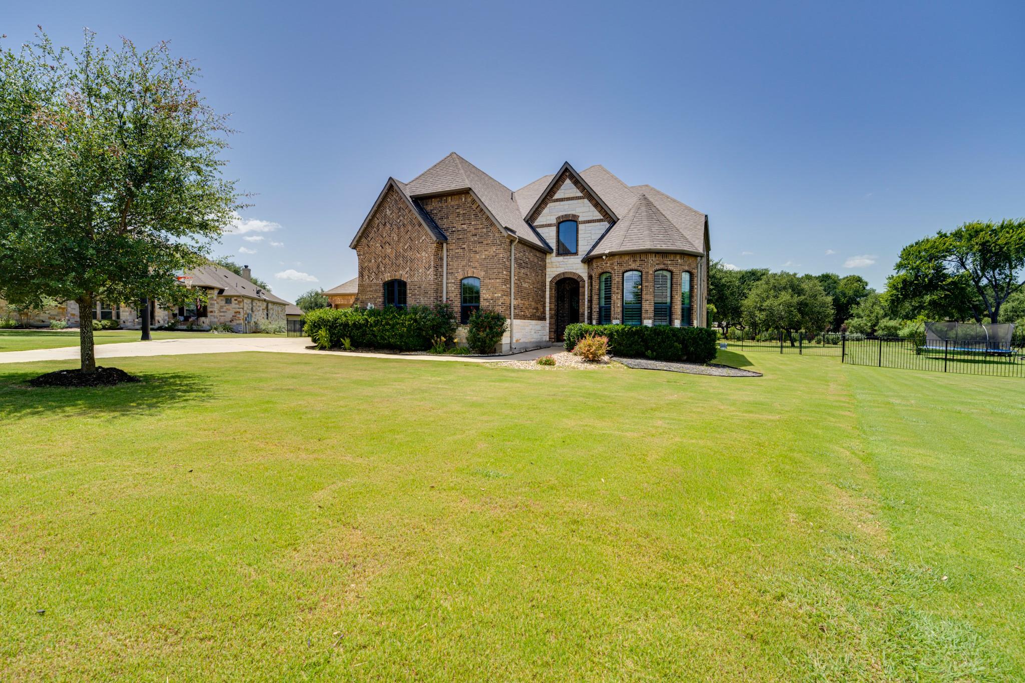 A spacious front yard and elegant brick facade cr
