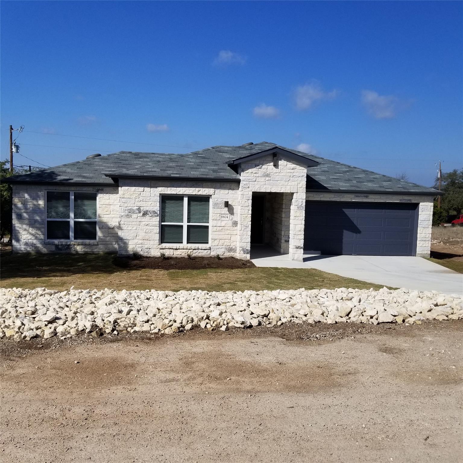 Stone veneer exterior with dark gray garage door 