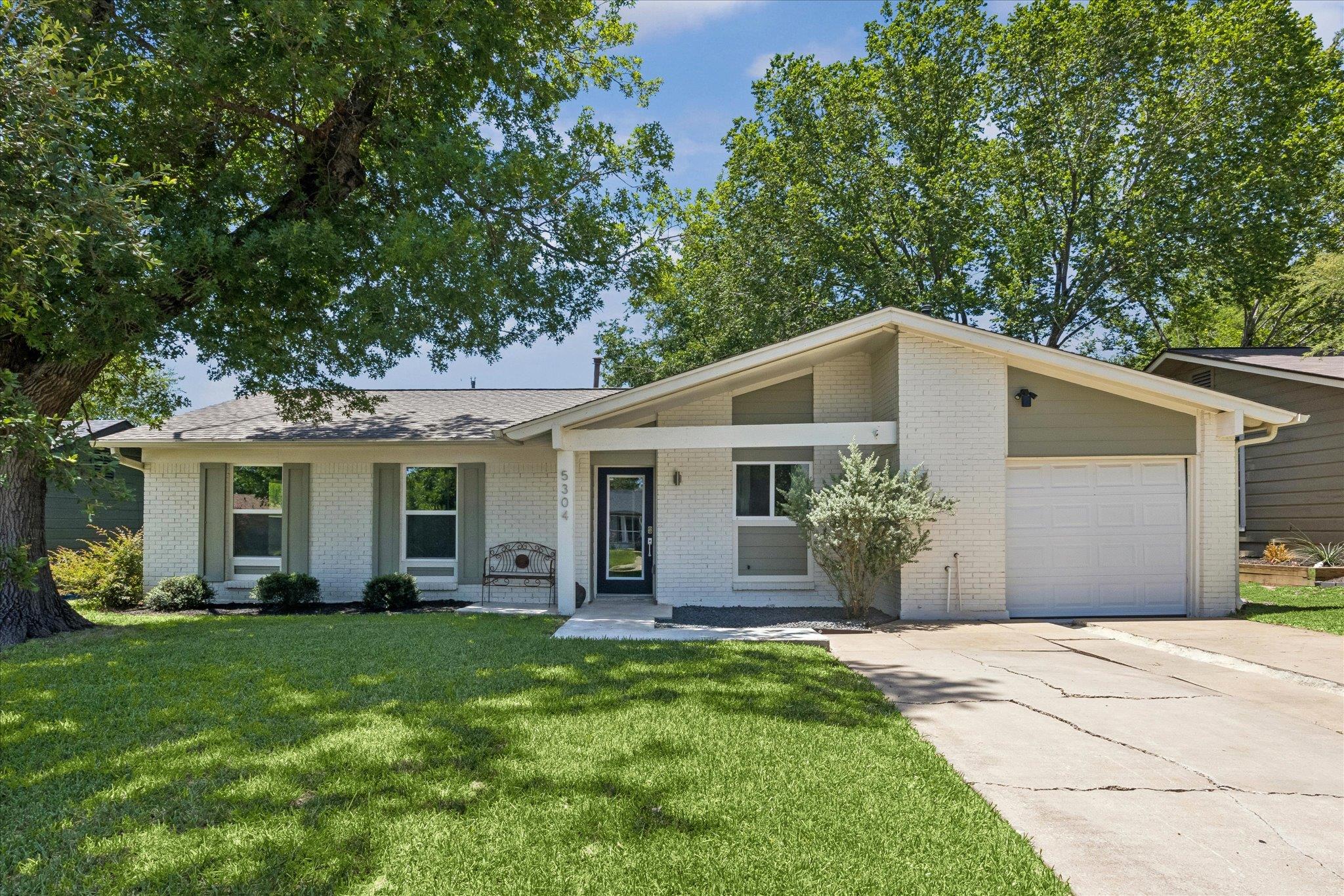 A classic ranch home, freshly painted, sits under